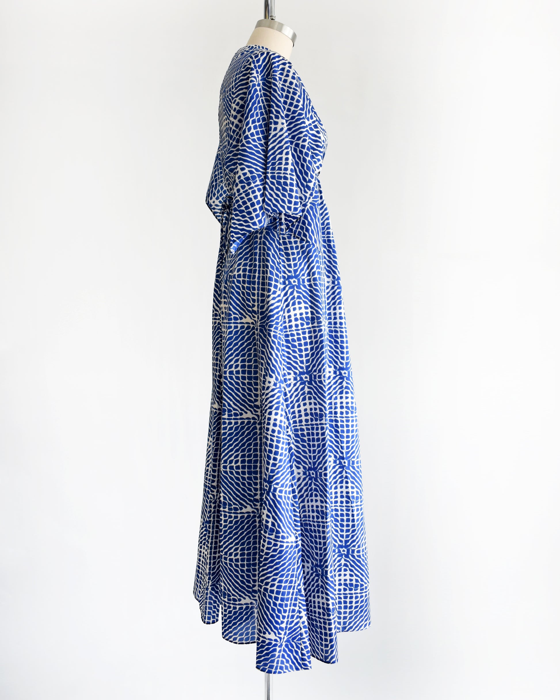 side view of a vintage 1970s blue and white caftan with handkerchief sleeves