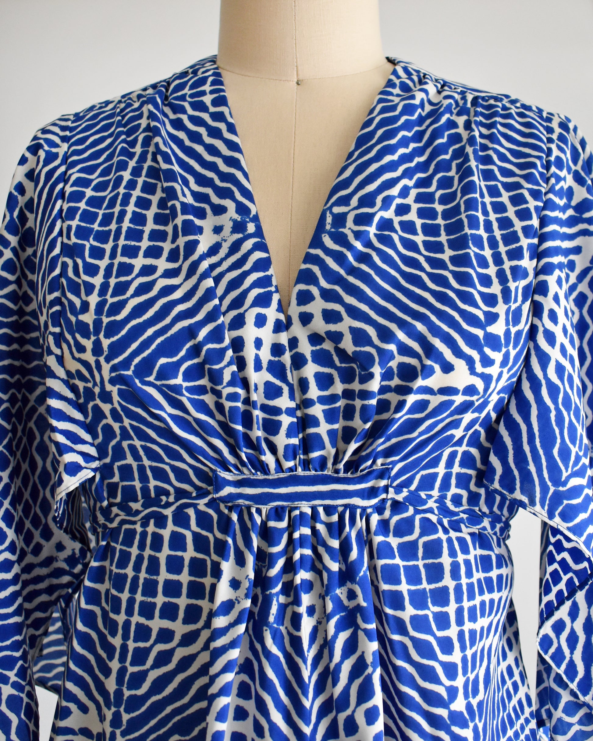 close up of the bodice of a vintage 1970s blue and white caftan with handkerchief sleeves