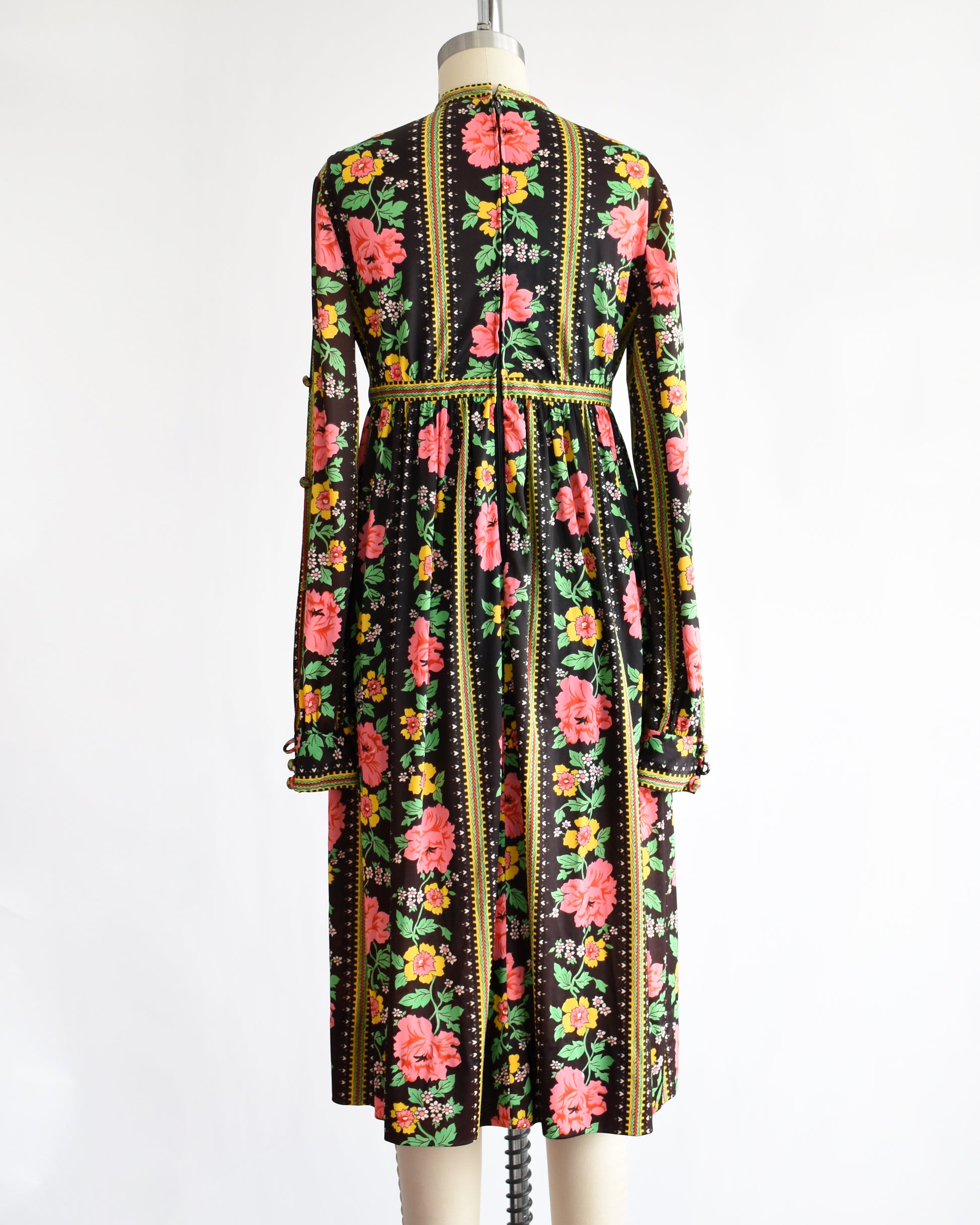 back view of a vintage 1960s/1970s floral dress on a mannequin against a white background