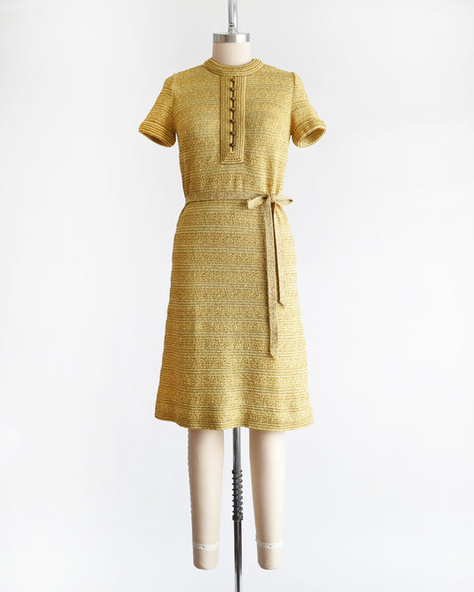 a vintage 1960s gold metallic dress on a mannequin against a white background
