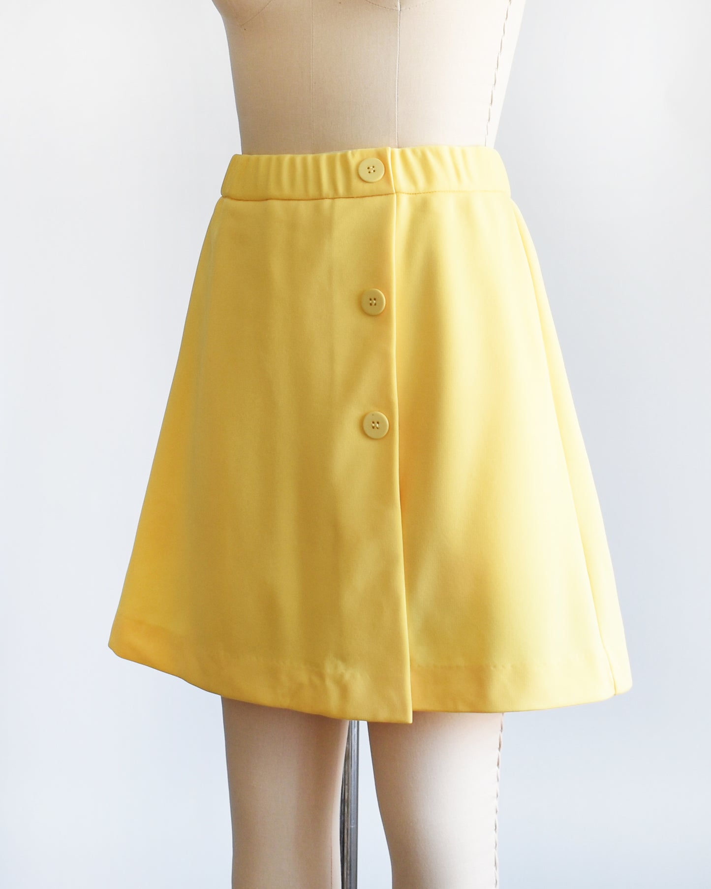 side front view of a vintage 1970s skort with three decorative buttons along the left side