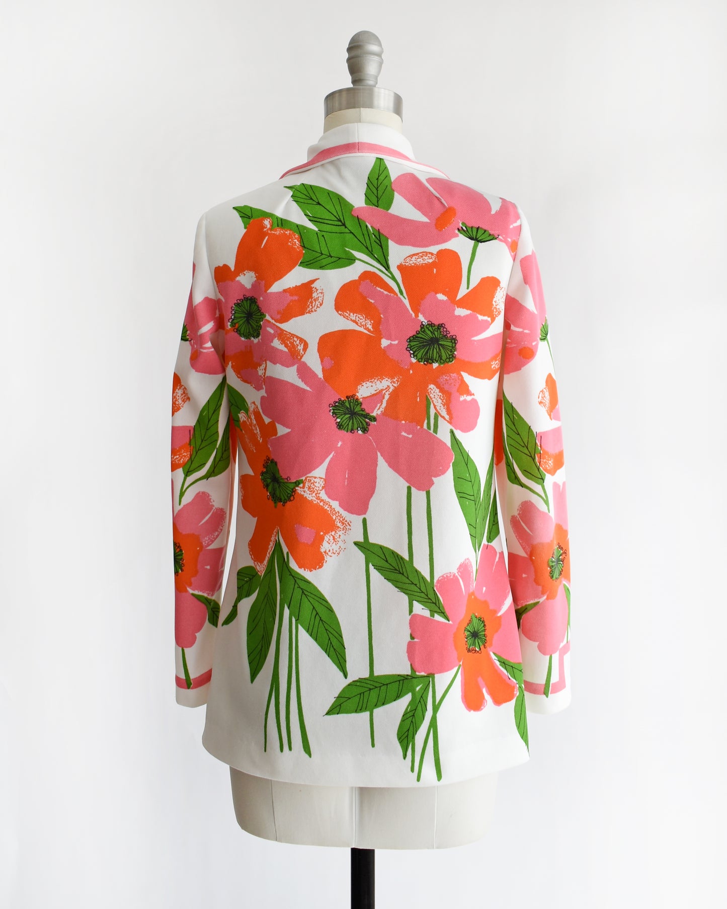 back view of a vintage 1970s floral patterned Vera shirt on a mannequin against a white background