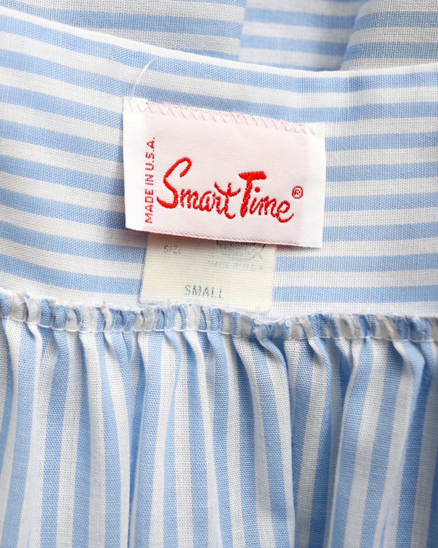 Close-up of a blue and white striped garment with a 'Smart Time' label.
