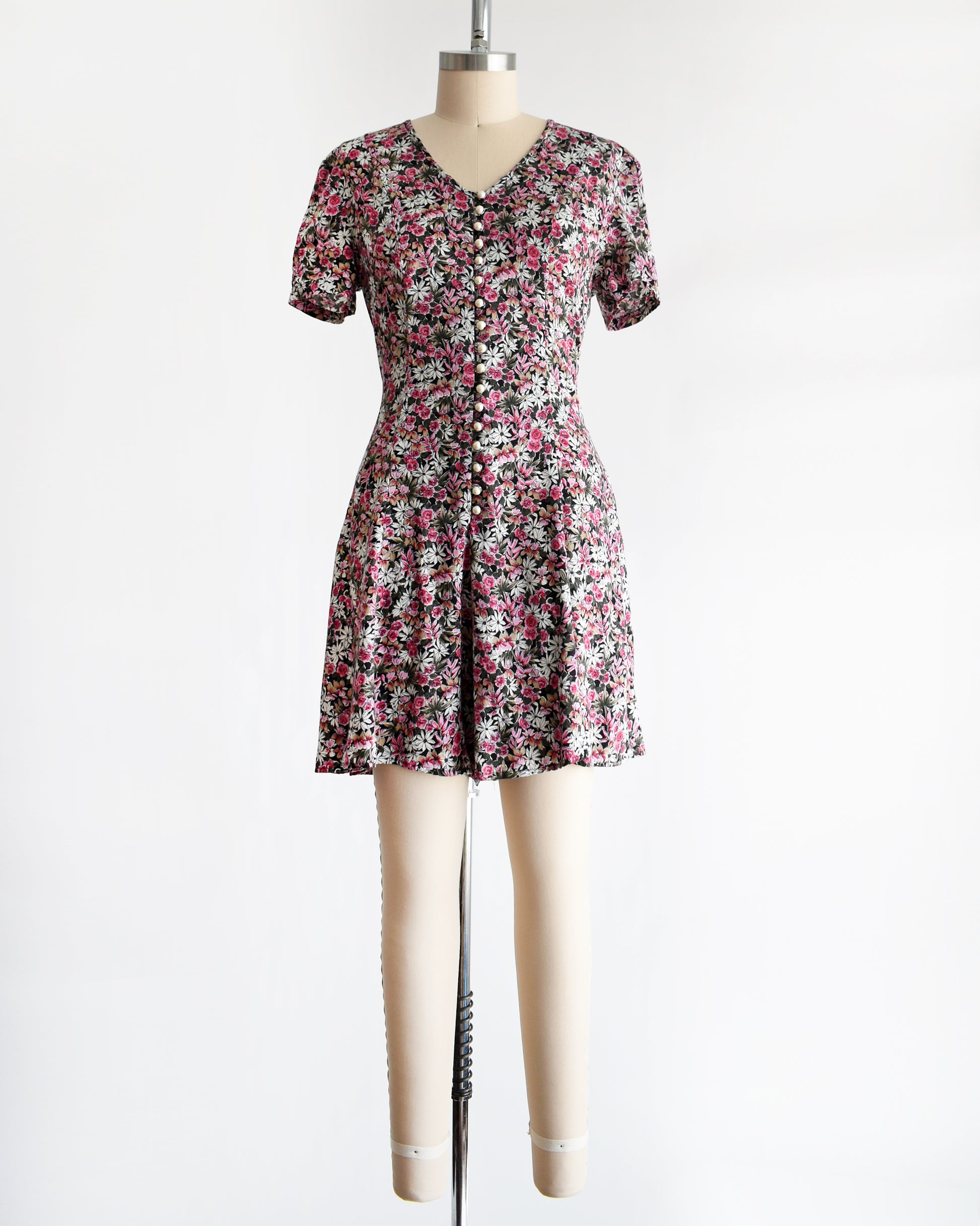 a vintage 1990s floral romper on a mannequin against a white background