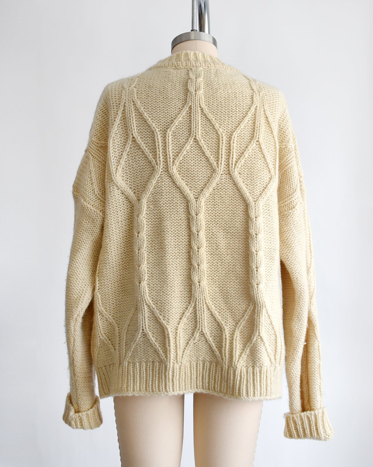 back view of a vintage 1990s cream cable knit wool cardigan