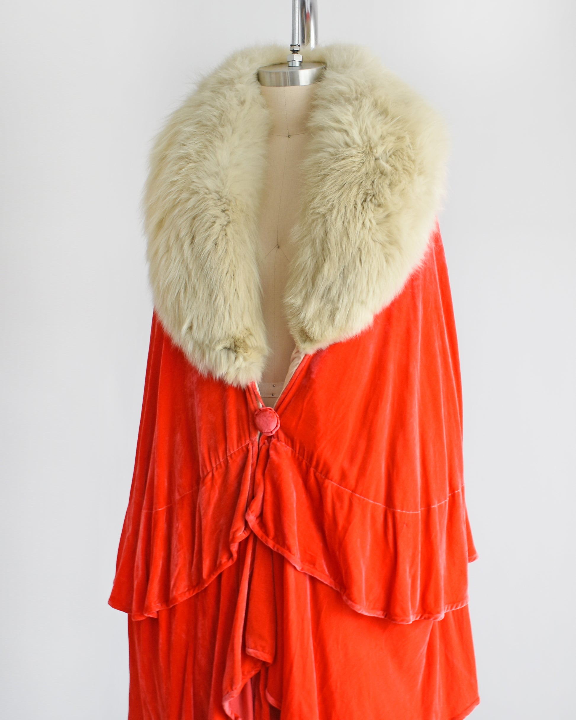 Side front view of a vintage 1920s ruffled silk velvet opera coat with cream fox fur trim