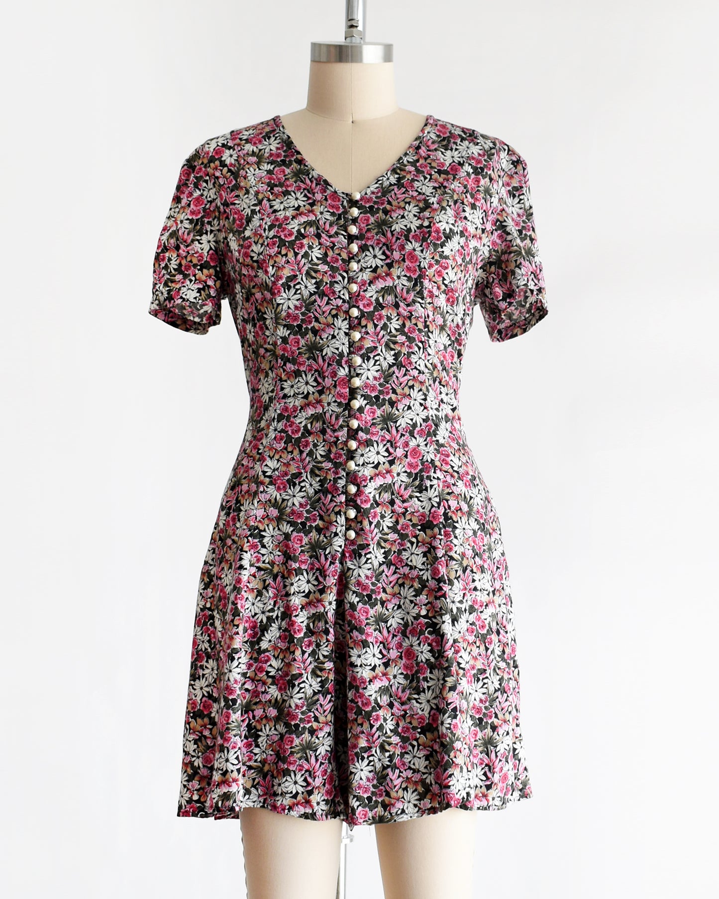 a vintage 1990s floral romper on a mannequin against a white background