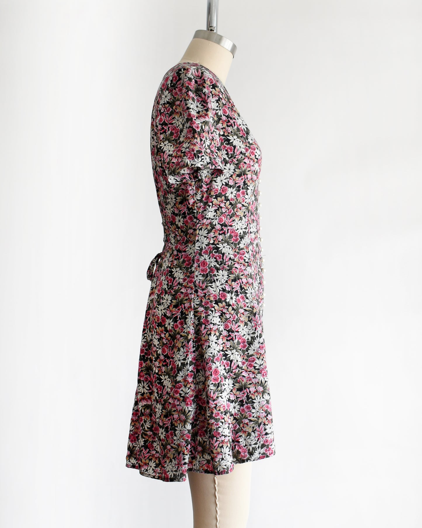 side view of a vintage 1990s floral romper on a mannequin against a white background