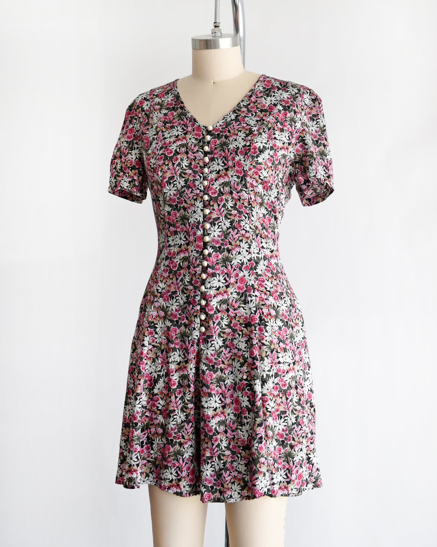 side view of a vintage 1990s floral romper on a mannequin against a white background