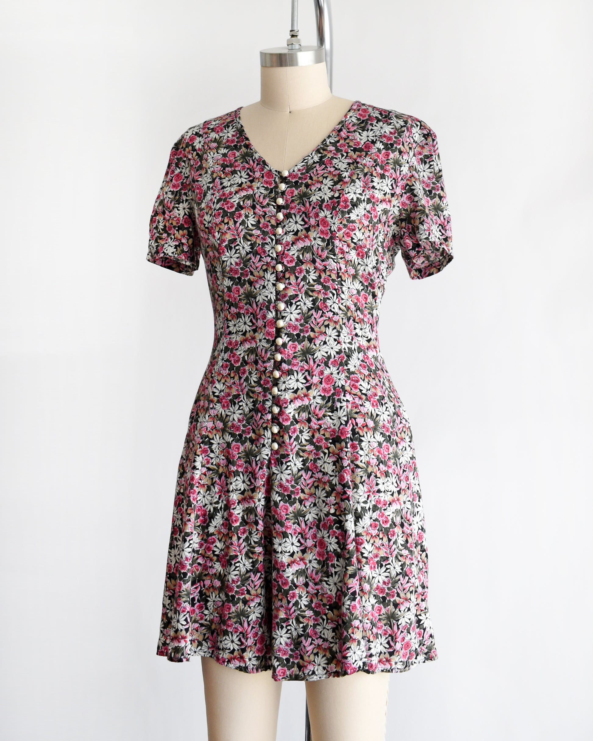 side view of a vintage 1990s floral romper on a mannequin against a white background