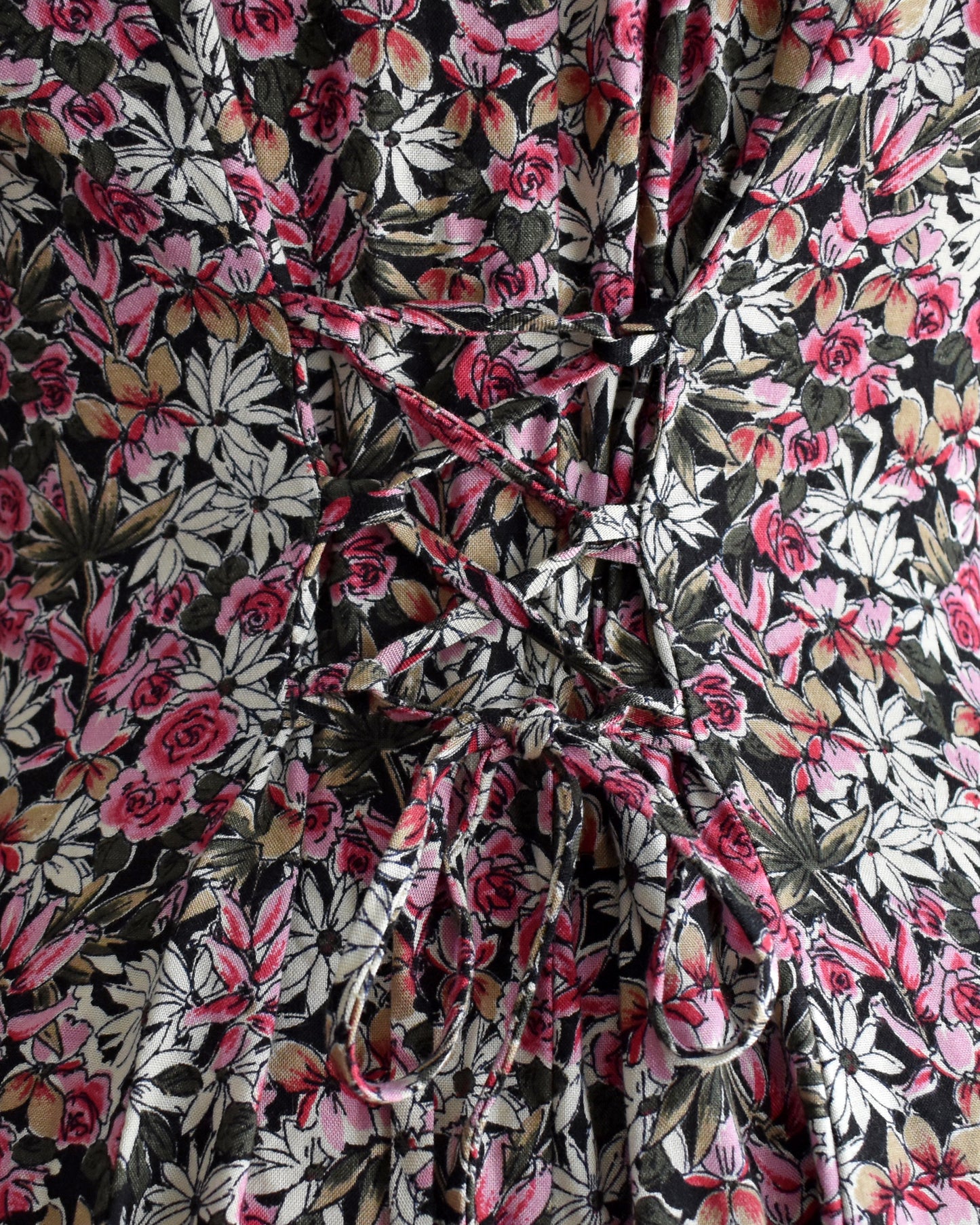 close up of the lace up back on a vintage 1990s floral romper on a mannequin against a white background