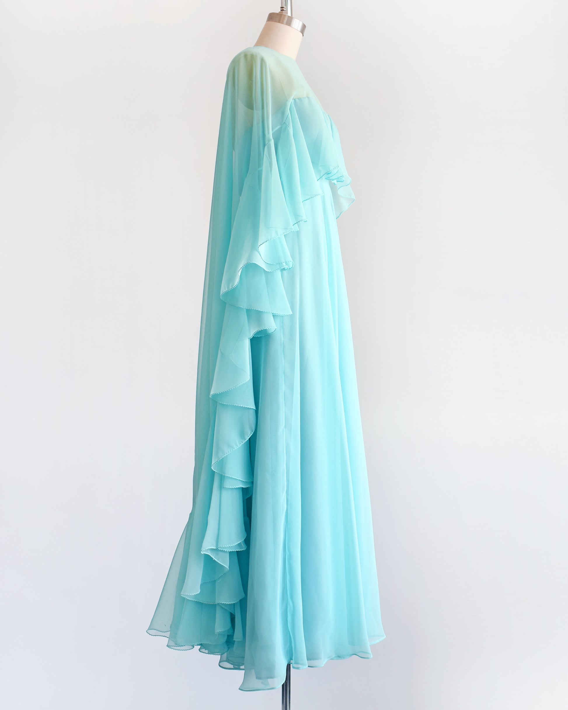 side view of a vintage 1960s light blue ruffled maxi dress on a mannequin against a white background