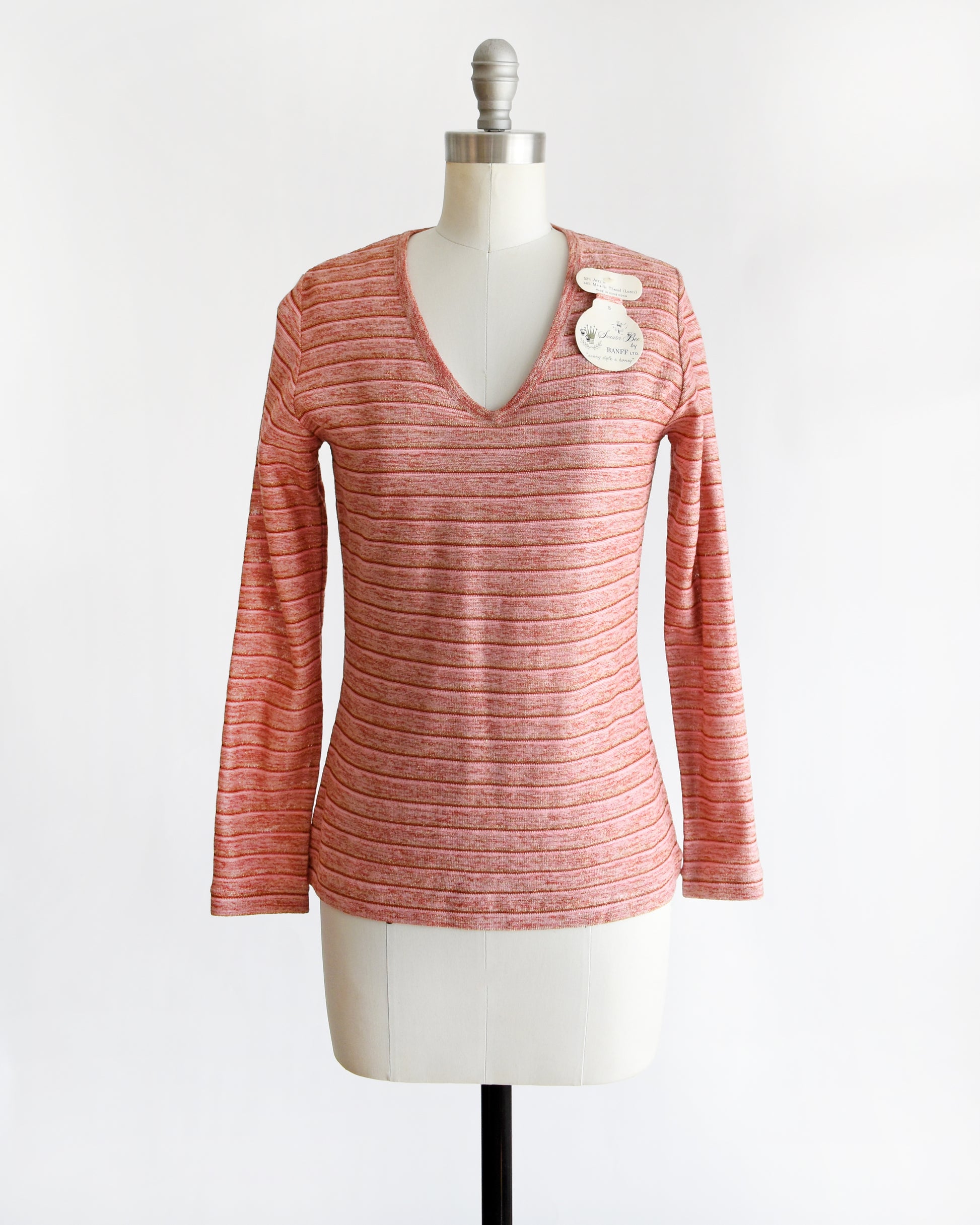a vintage 1970s pink long-sleeve top on a mannequin with a white background