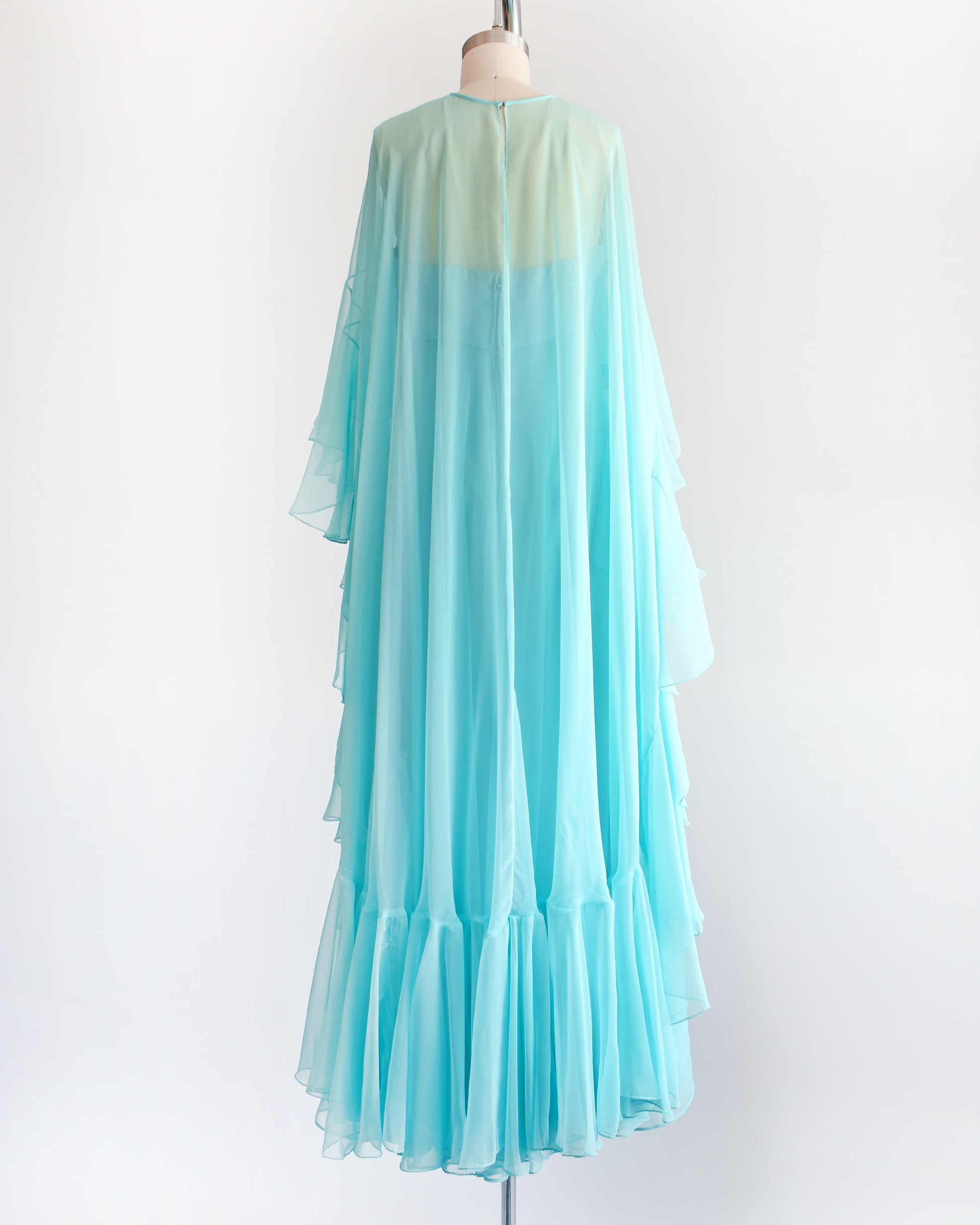 back view of a vintage 1960s light blue ruffled maxi dress on a mannequin against a white background