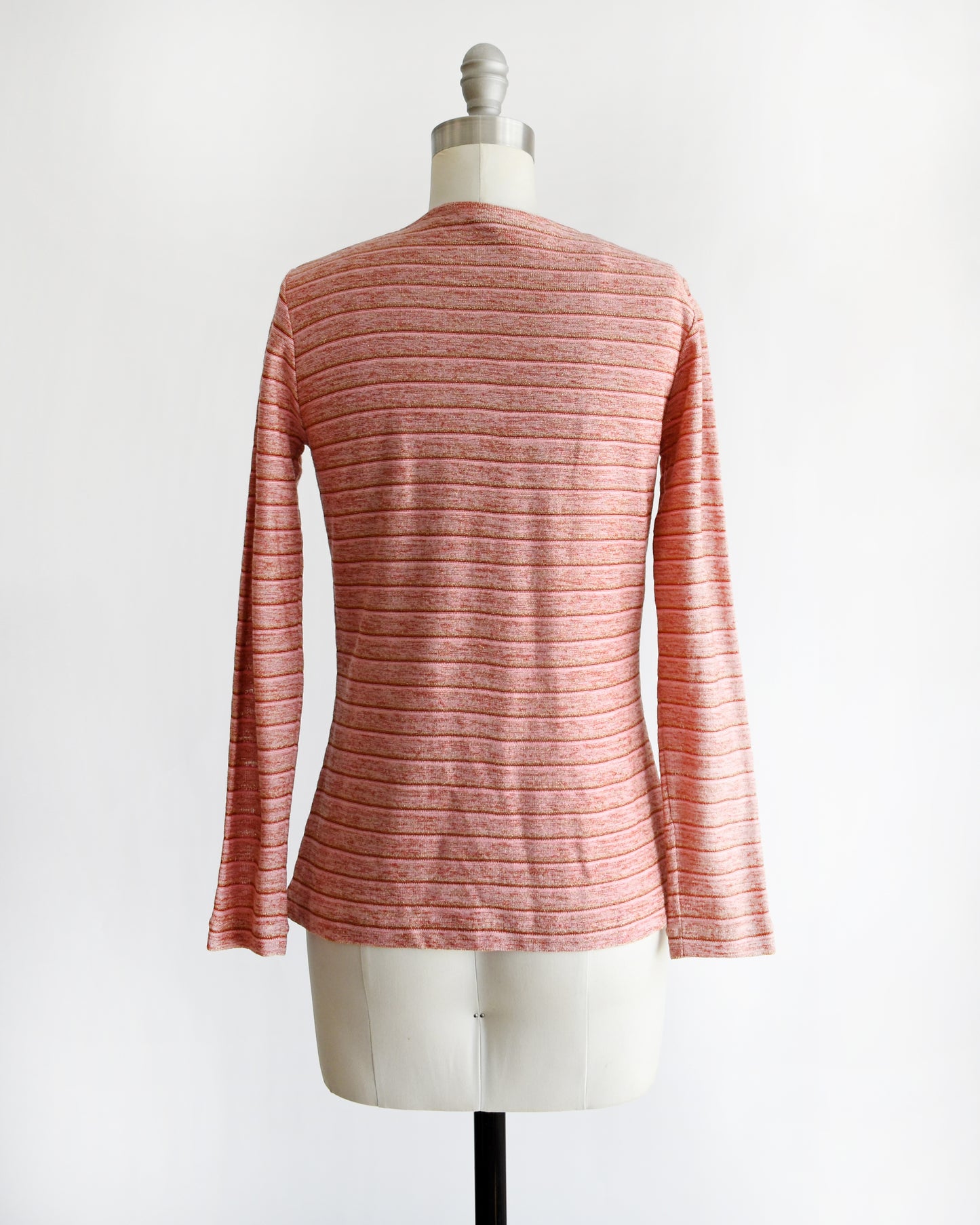 back view of a vintage 1970s pink long-sleeve top on a mannequin with a white background