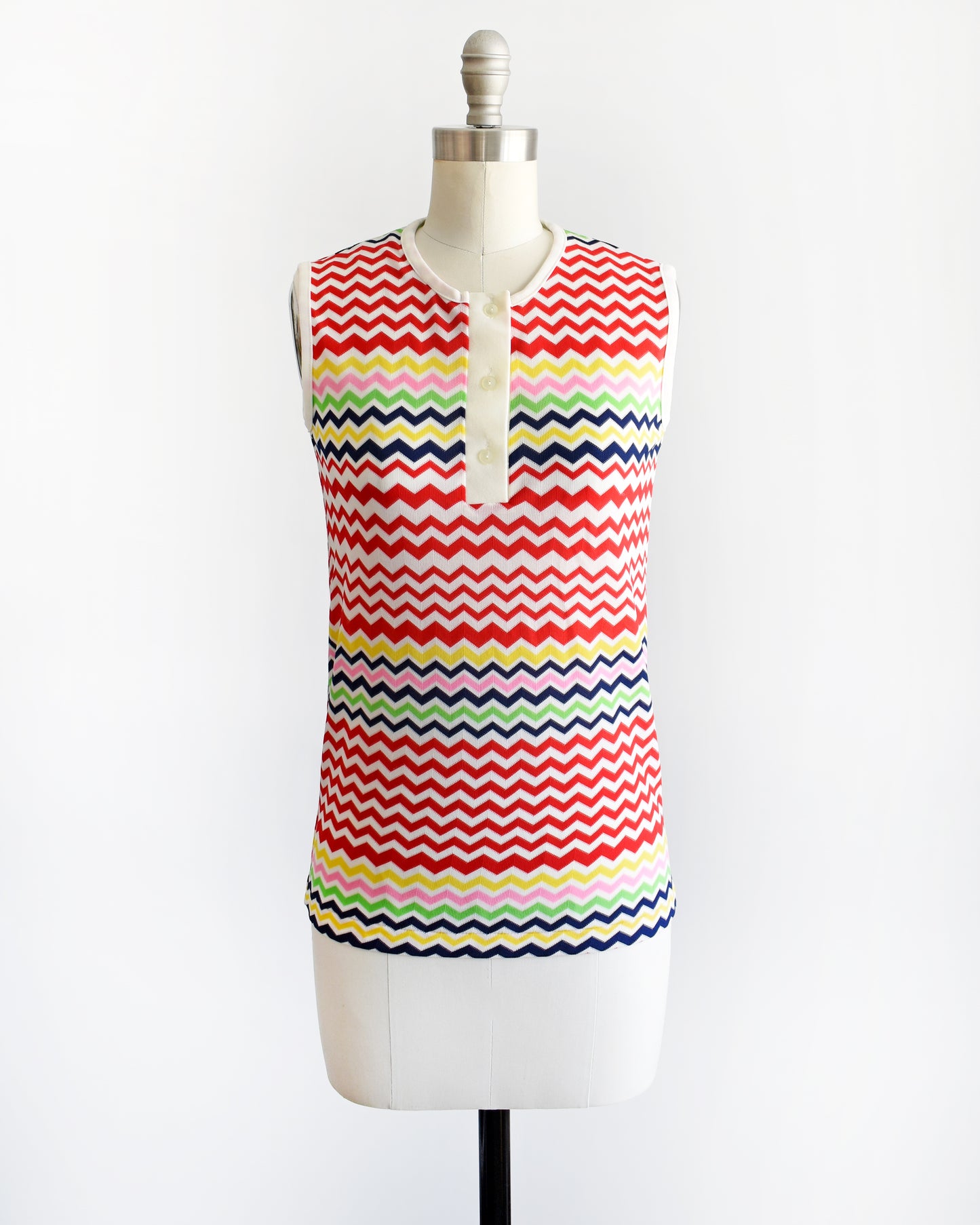 A vintage 1970s colorful zigzag patterned sleeveless top on a mannequin against a white background