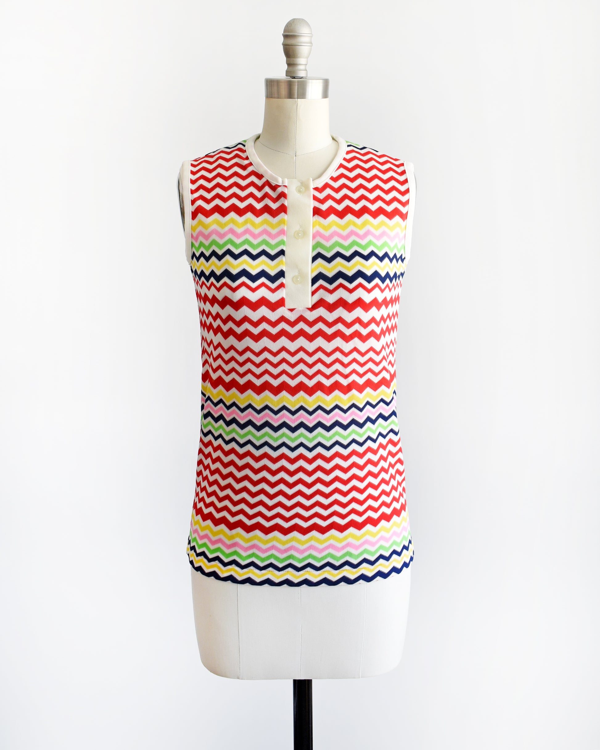 A vintage 1970s colorful zigzag patterned sleeveless top on a mannequin against a white background