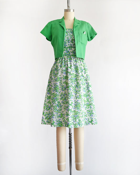 a vintage 1970s green floral dress with green bolero on a mannequin against a white background