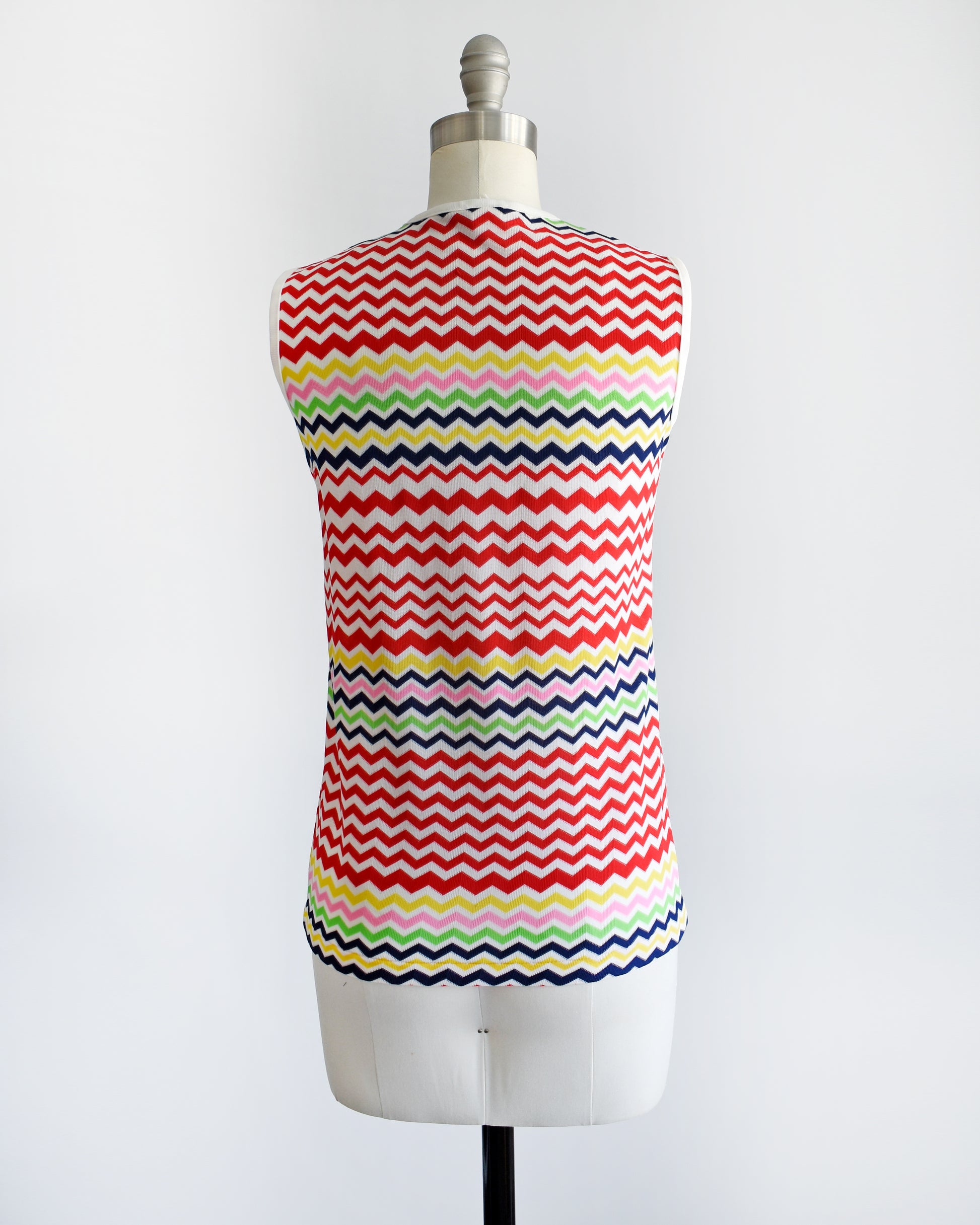 back view of a vintage 1970s colorful zigzag patterned sleeveless top on a mannequin against a white background