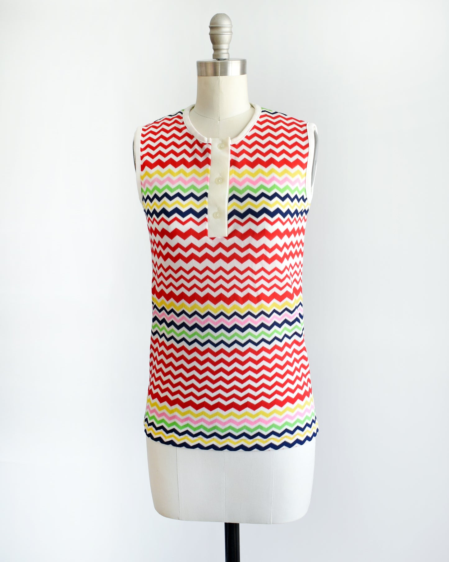 side front view of a vintage 1970s colorful zigzag patterned sleeveless top on a mannequin against a white background
