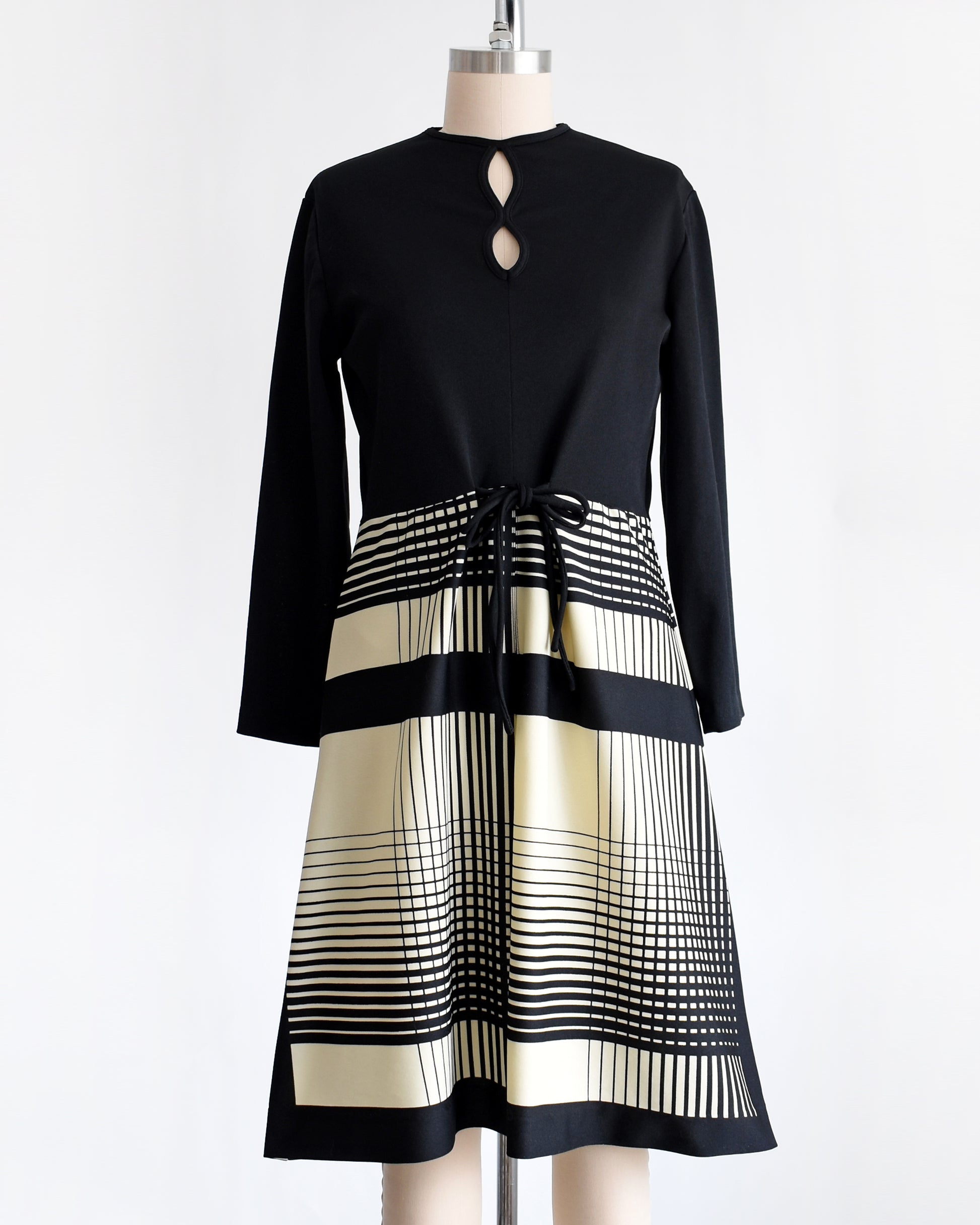 a vintage 1970s black and cream striped dress that has two keyhole cutouts on the front of the bodice.