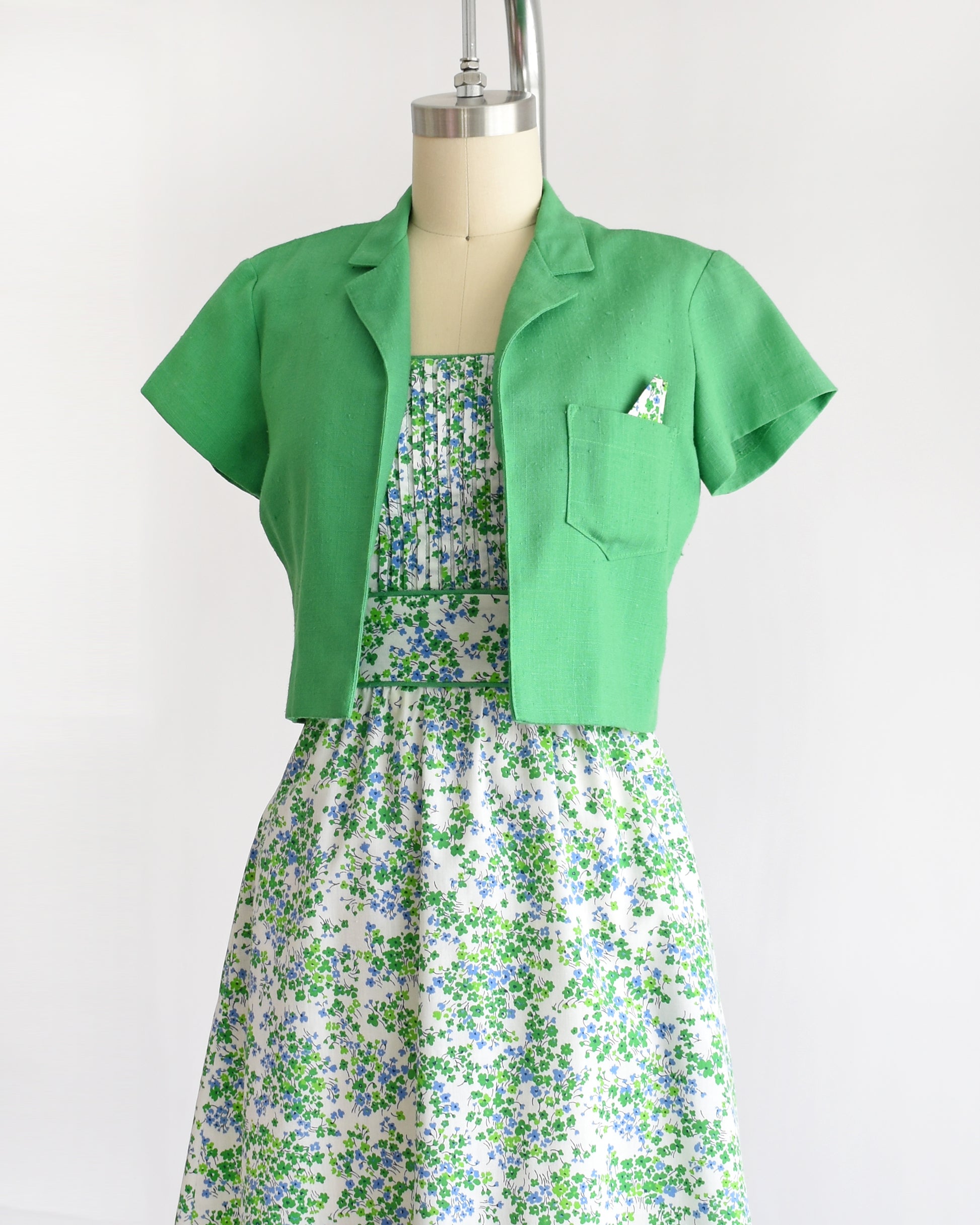 side front view of side by side side views of a vintage 1970s green floral dress with green bolero on a mannequin against a white background. 