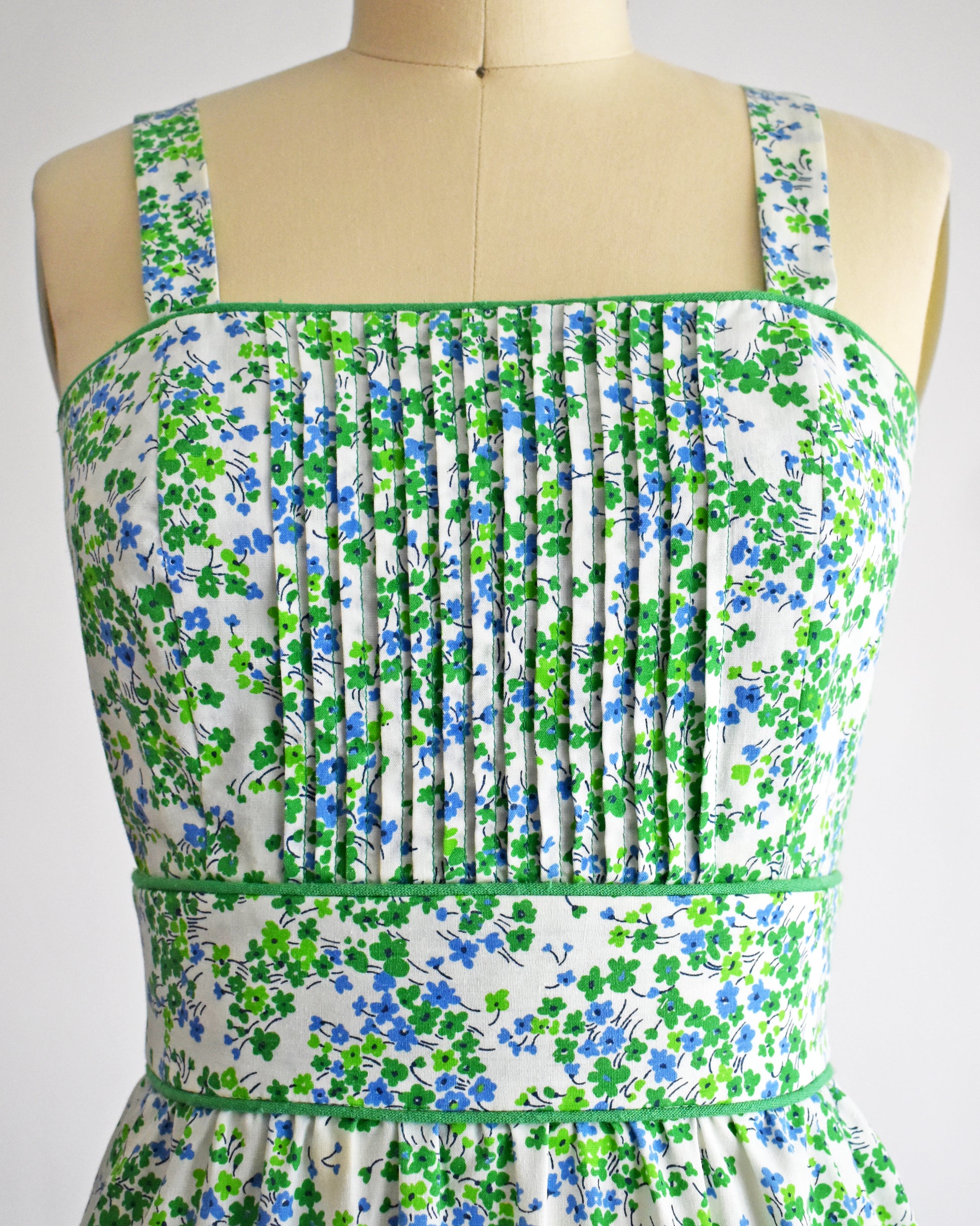 close up of the pleated bodice on a mannequin against a white background.