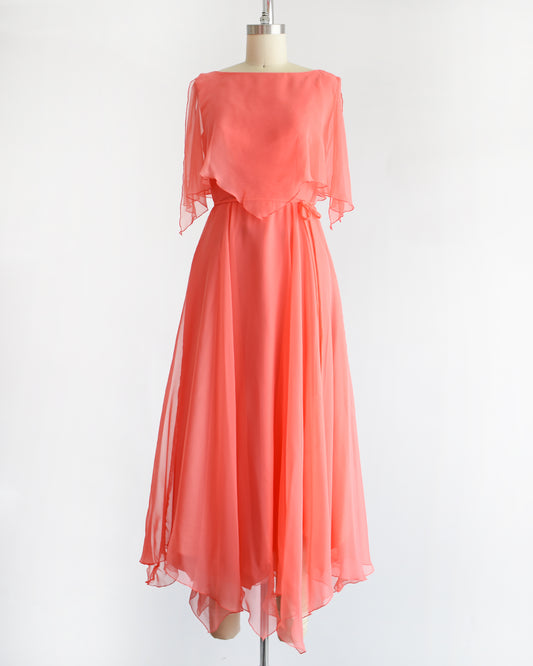 a vintage 1970s coral flutter dress on a mannequin against a white background
