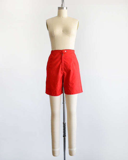 a pair of vintage 1960s red shorts on a mannequin against a white background
