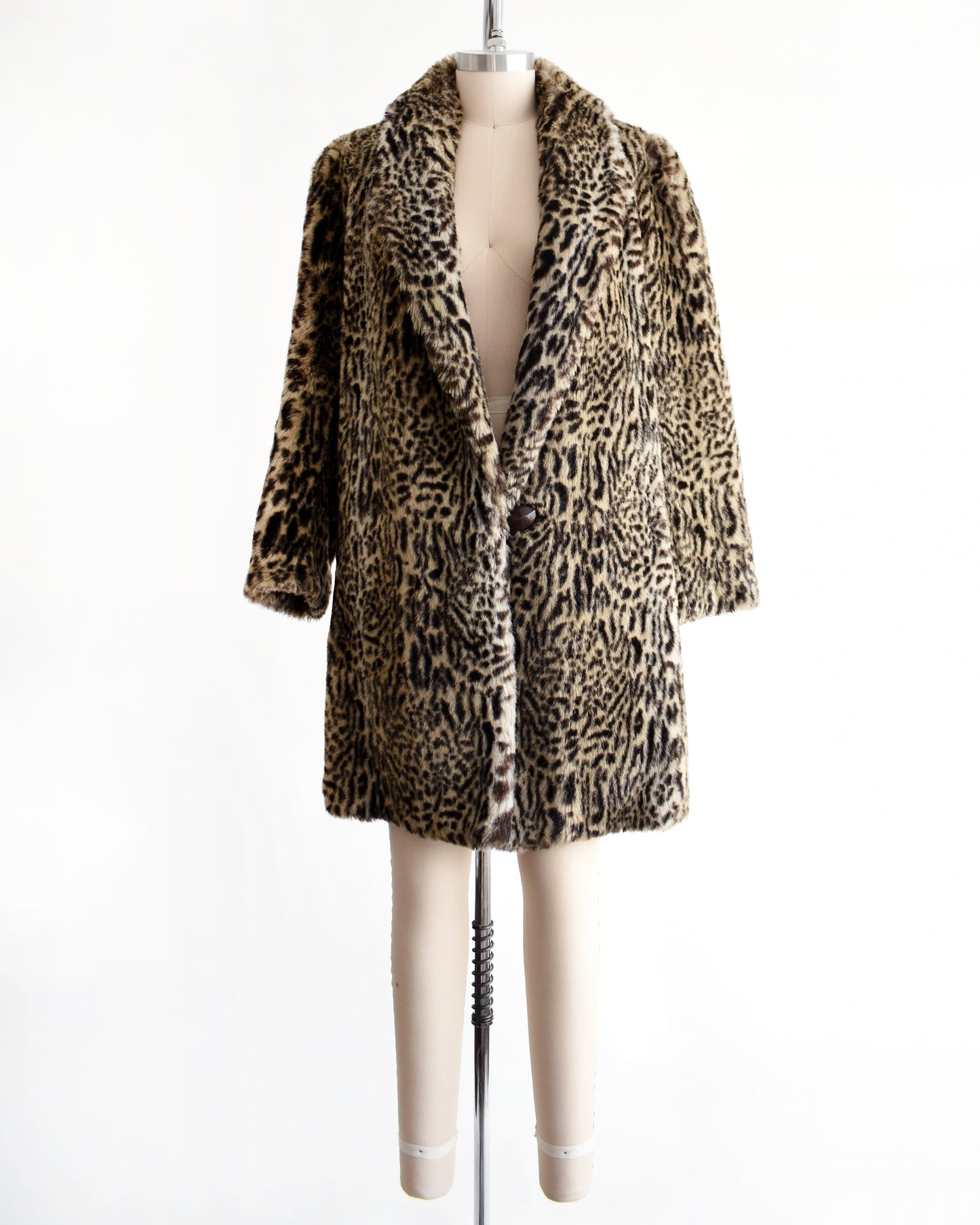 a vintage 1980s faux fur leopard print coat on a mannequin against a white background