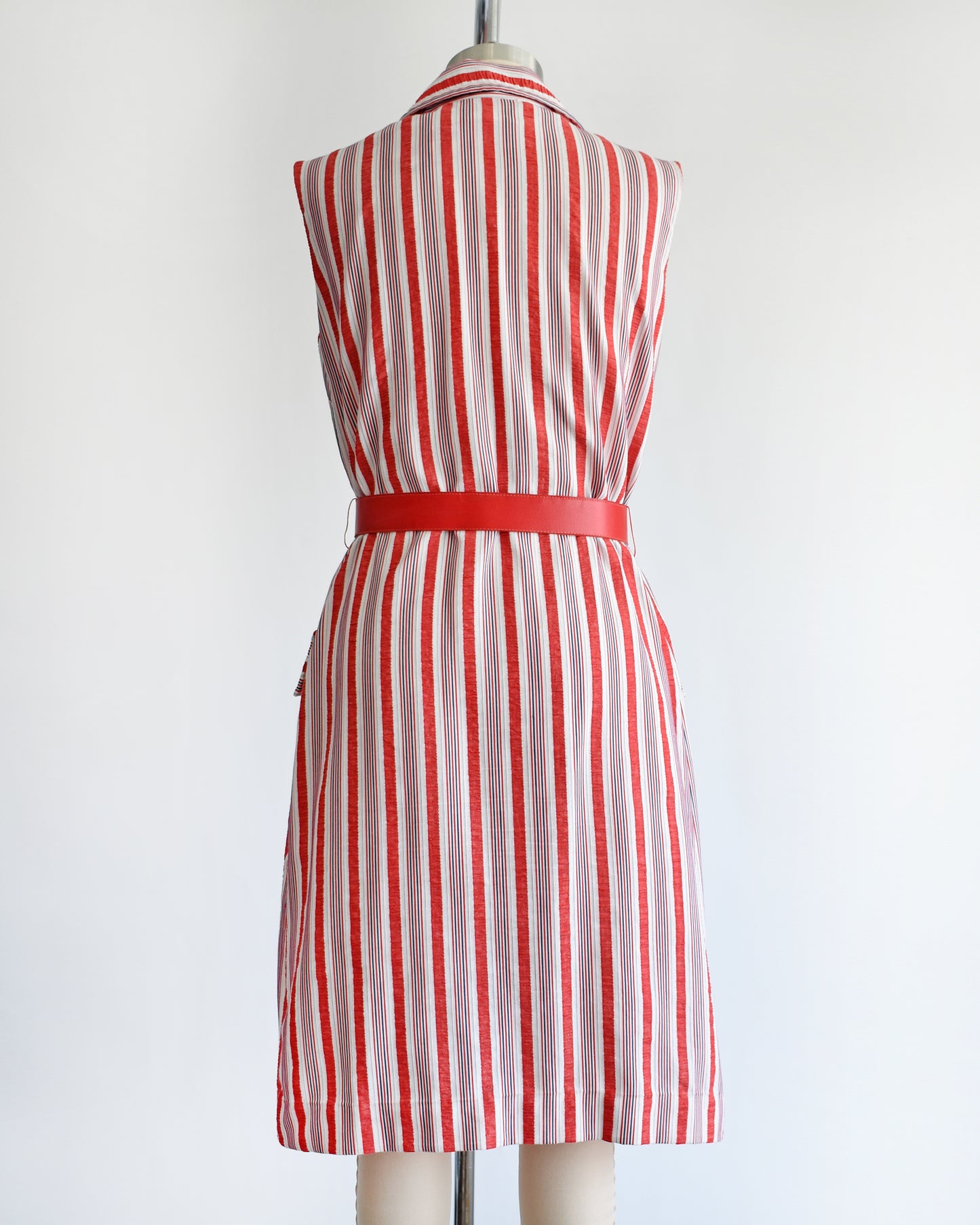 back view of a vintage 1970s red and white striped dress on a mannequin against a white background