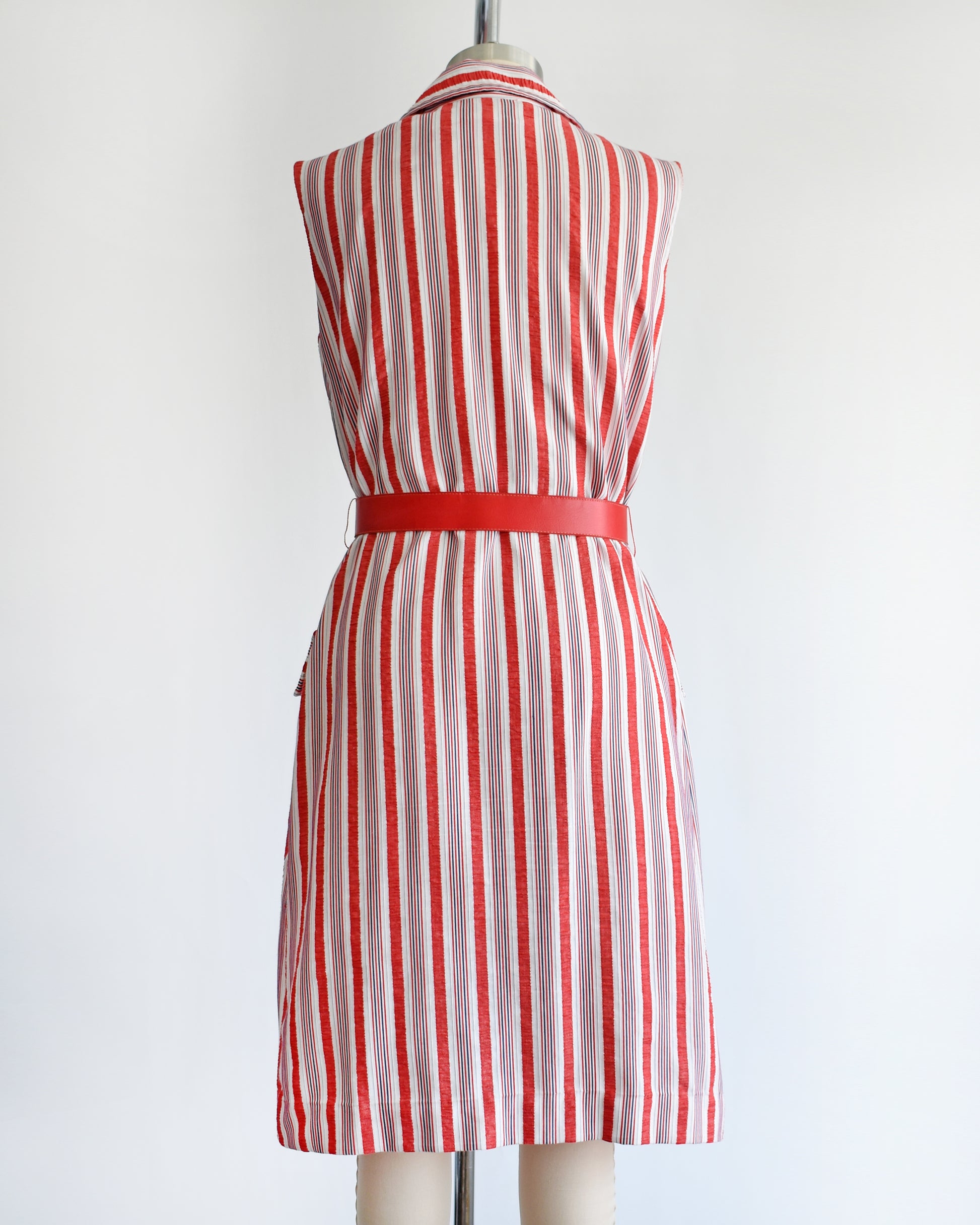 back view of a vintage 1970s red and white striped dress on a mannequin against a white background