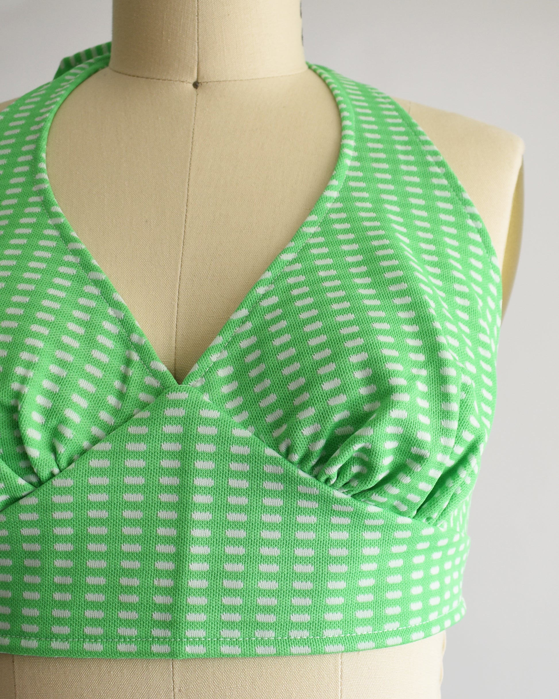 close up of the halter top which is green and has a white rectangle print