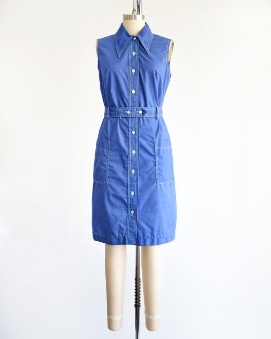 a vintage 1970s blue button front dress on a mannequin against a white background