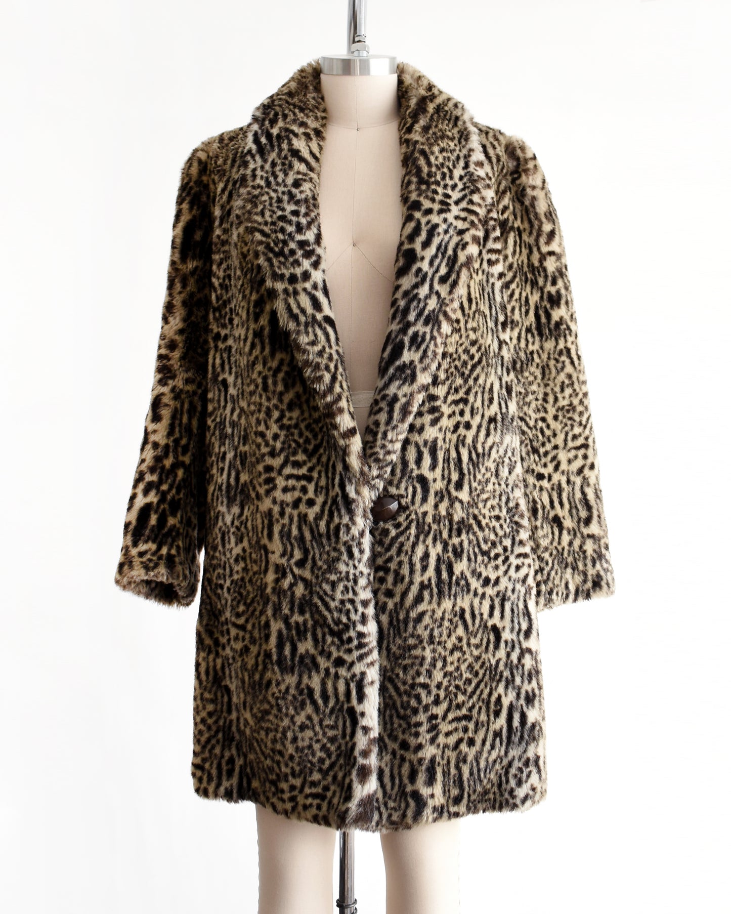 a vintage 1980s faux fur leopard print coat on a mannequin against a white background