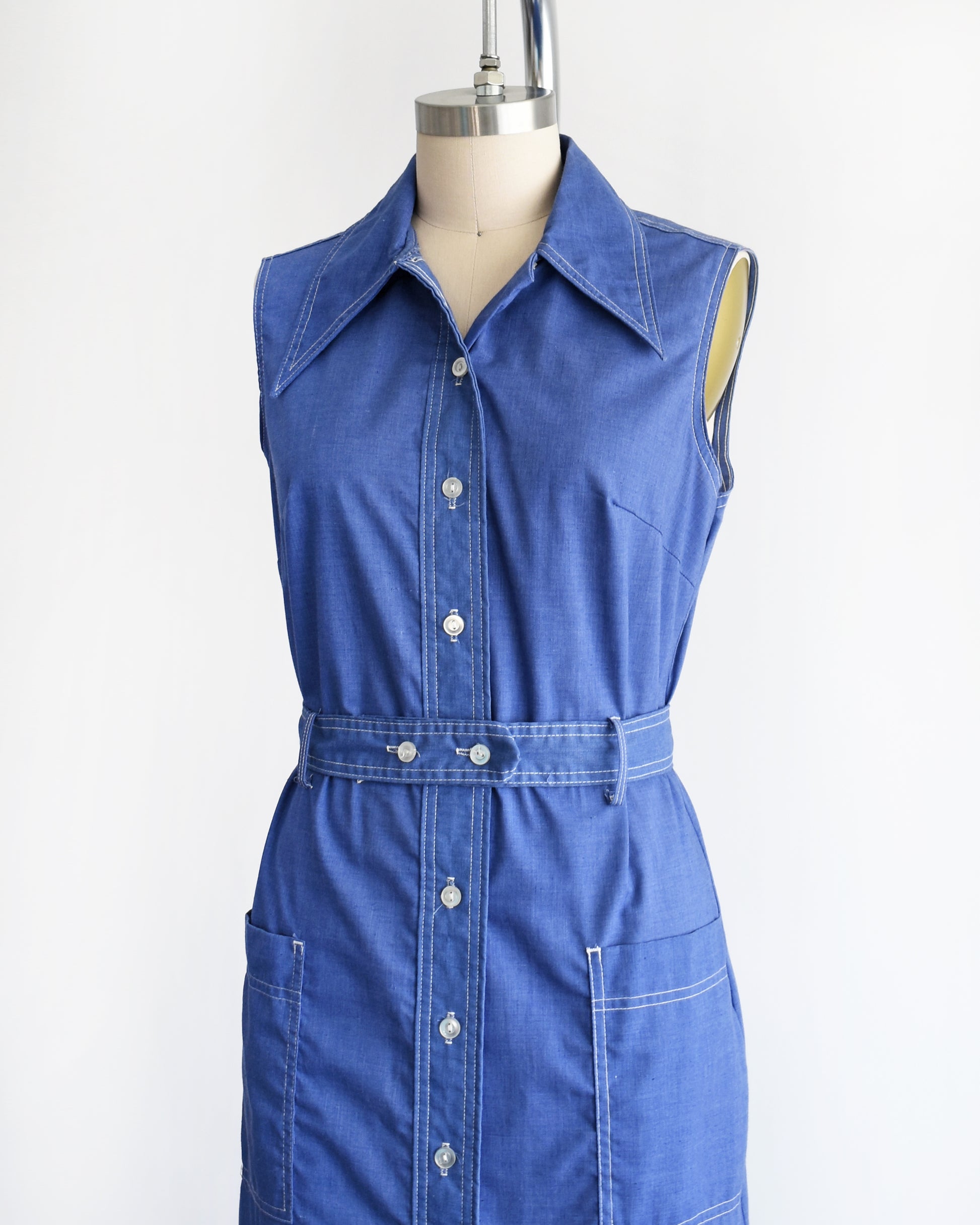 side front view of a vintage 1970s blue dress on a mannequin against a white background