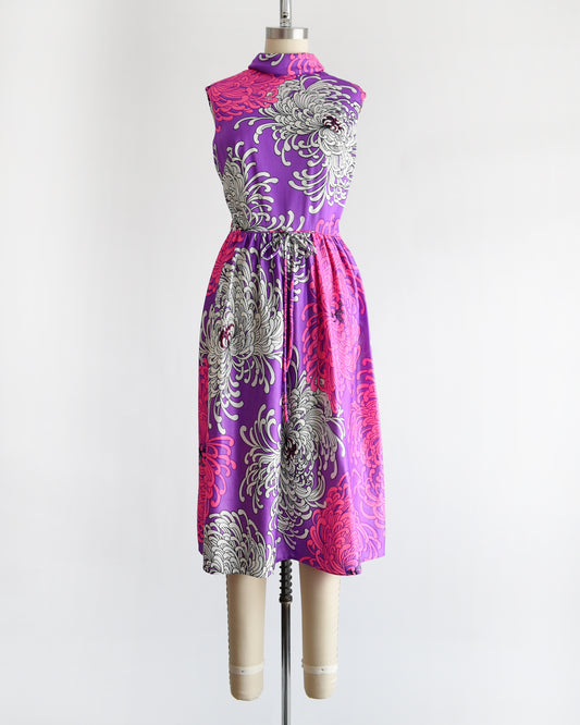 a vintage 1970s purple dress with floral patterns on a mannequin against a white background