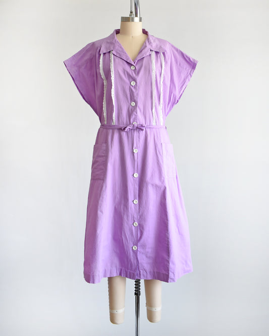 A vintage 1950s purple dress by Fruit of the Loom on a mannequin against a white background