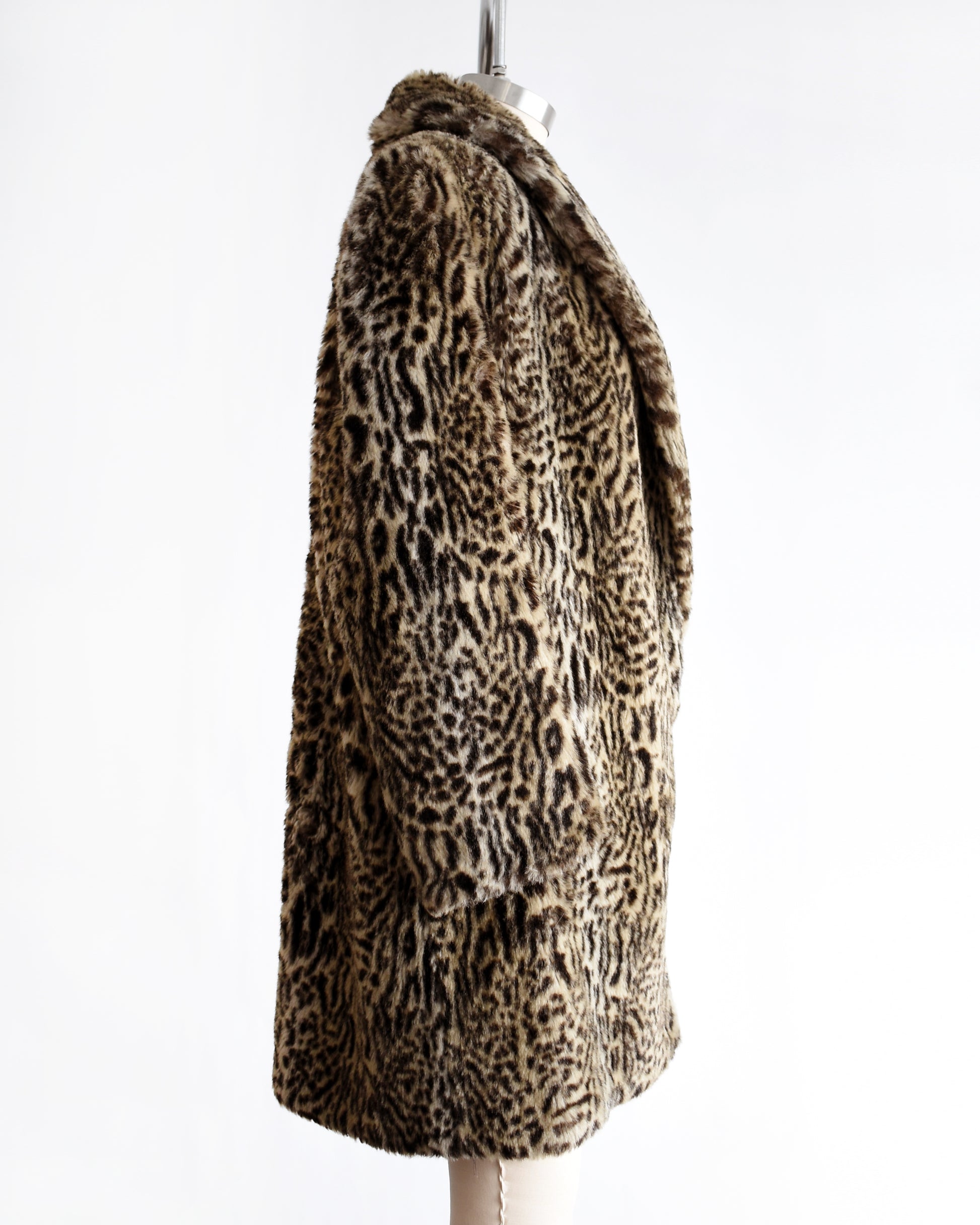 side view of a vintage 1980s faux fur leopard print coat on a mannequin against a white background