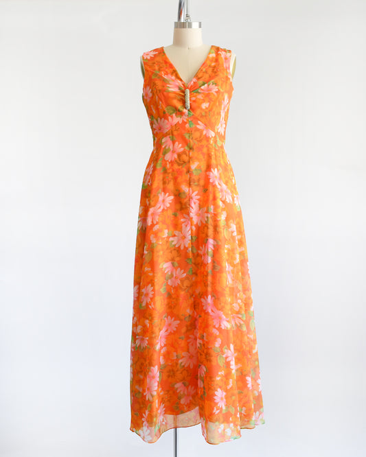 A vintage late 1960s early 1970s chiffon floral maxi dress with rhinestone brooch at the center