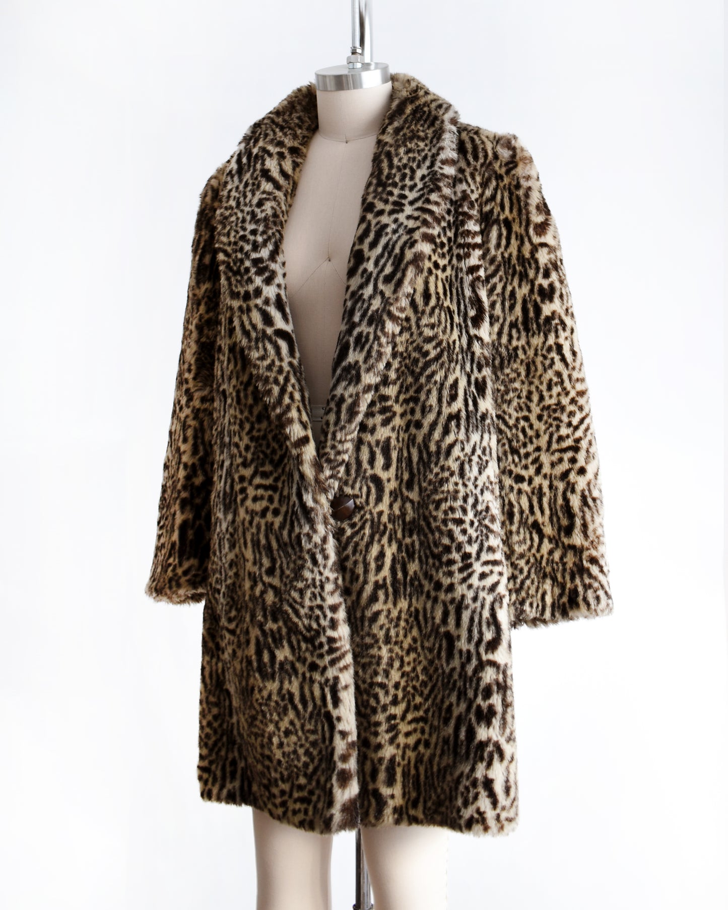 side view of a vintage 1980s faux fur leopard print coat on a mannequin against a white background