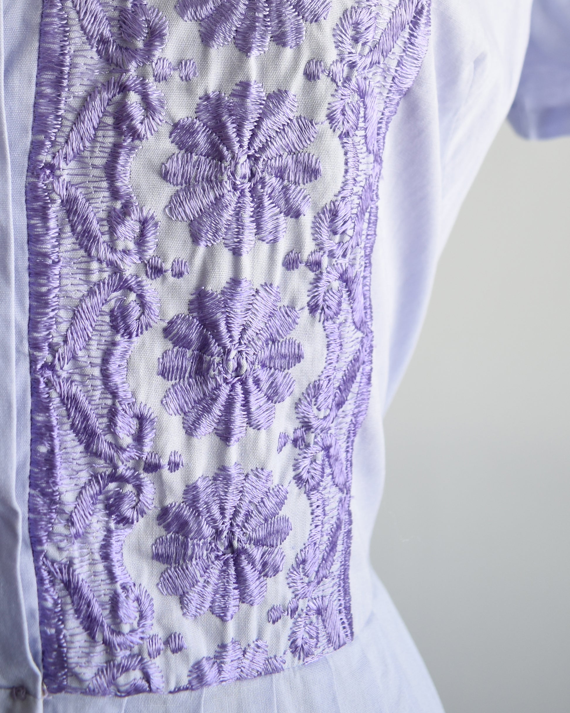 Close-up of the bodice which shows the dark purple floral embroidery