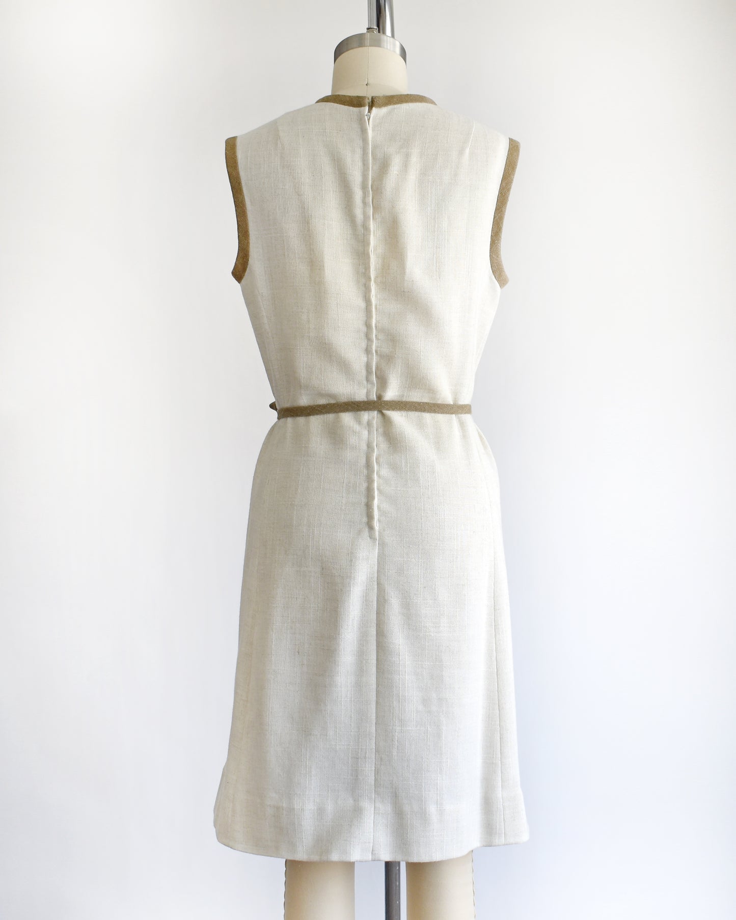 back view of a vintage 1970s dress with butterfly design on a mannequin against a white background