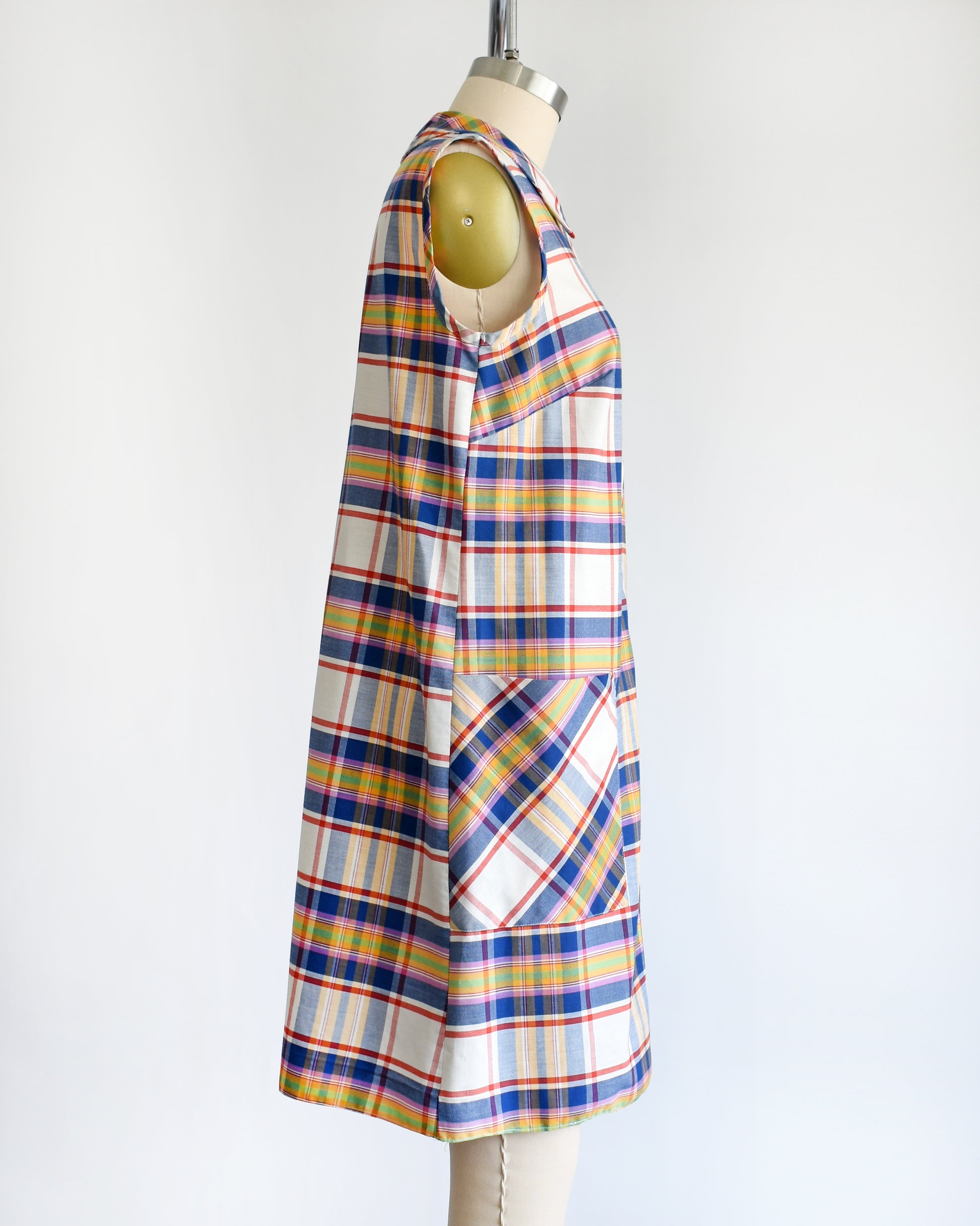 side view of a vintage 1960s/1970s plaid dress on a mannequin against a white background
