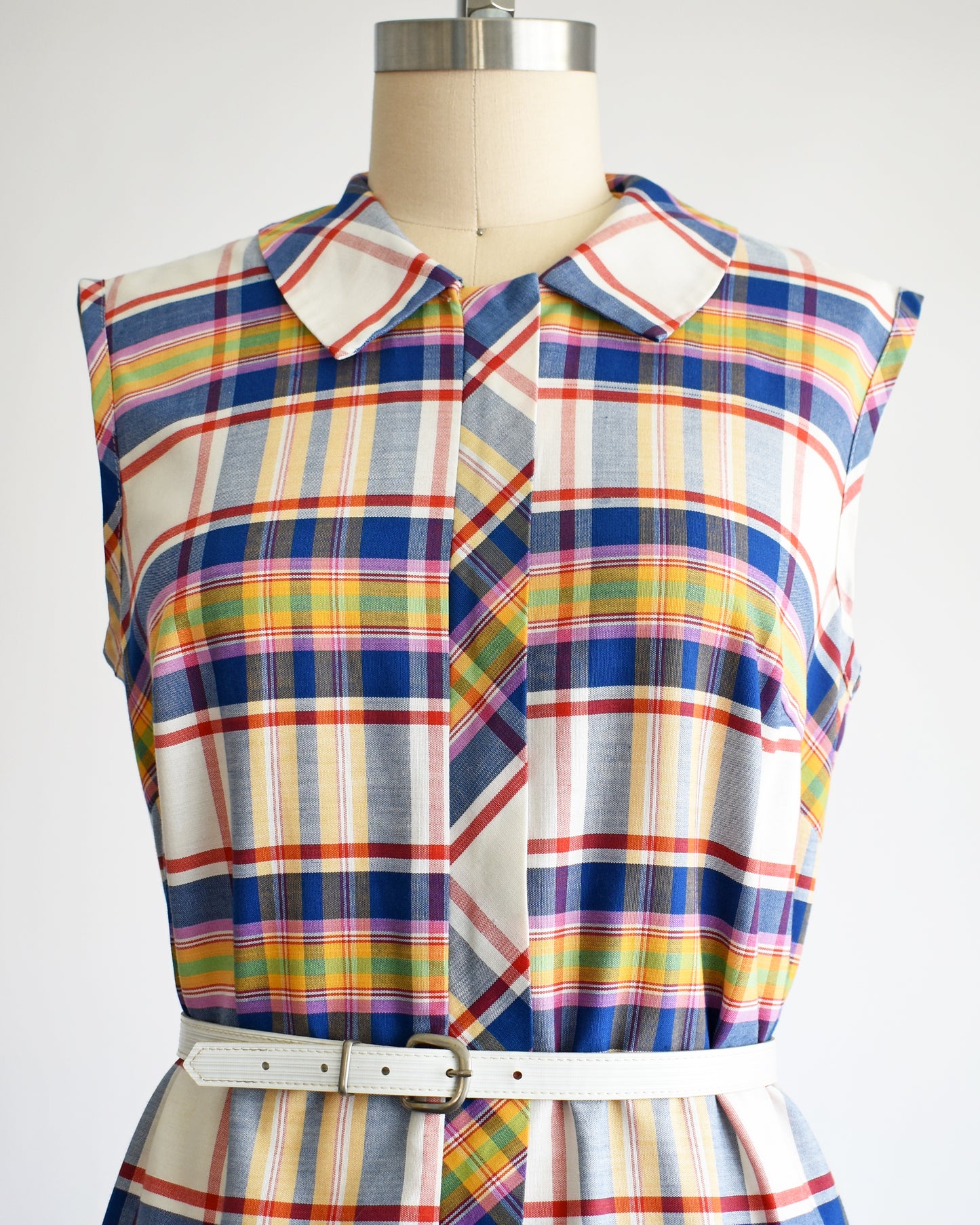 the bodice of a vintage 1960s/1970s plaid dress on a mannequin against a white background