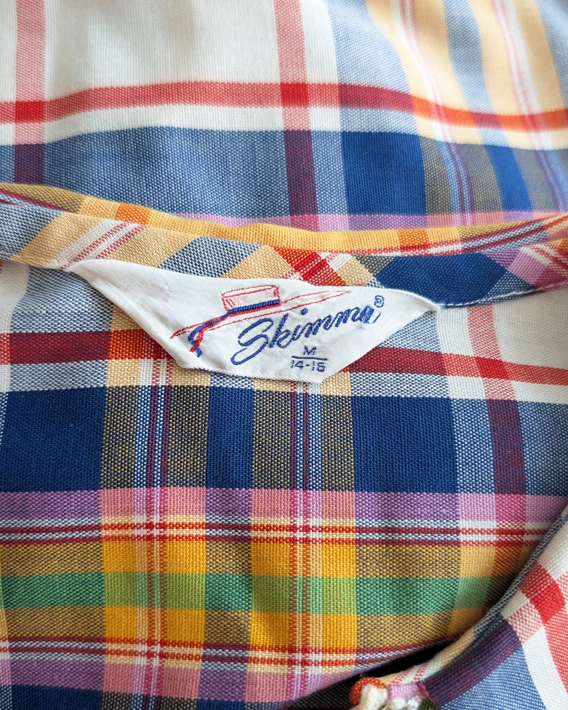 Colorful plaid fabric with a visible 'Skimma' label.