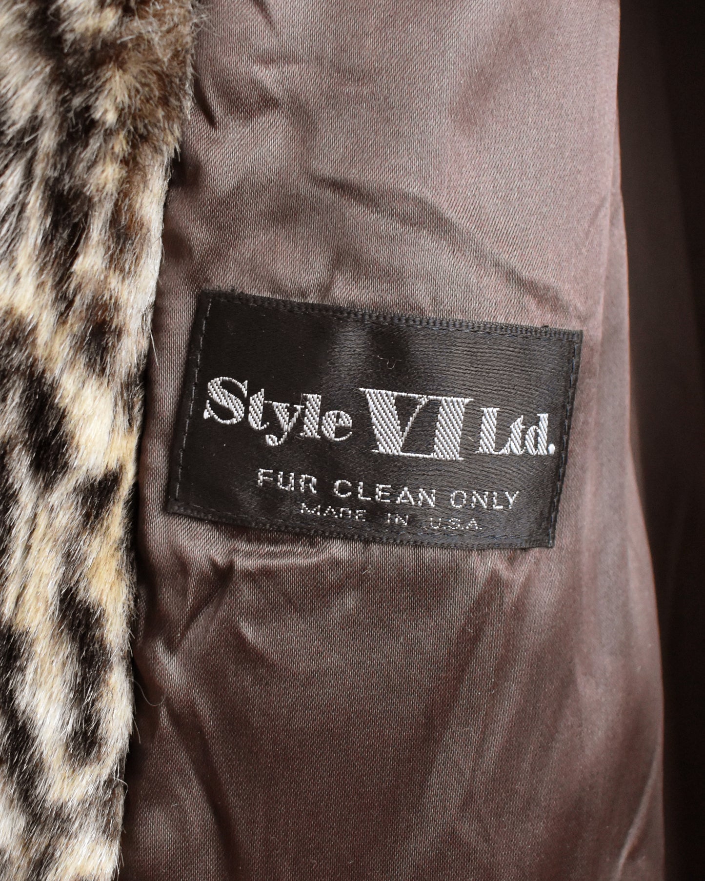 Close-up the 'Style VII Ltd.' label on a dark background