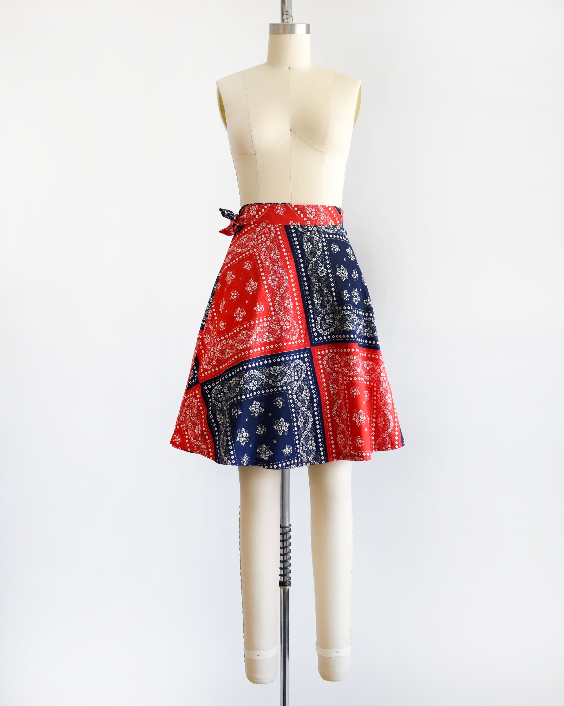 a vintage 1970s red and blue bandana patterned skirt on a mannequin against a white background
