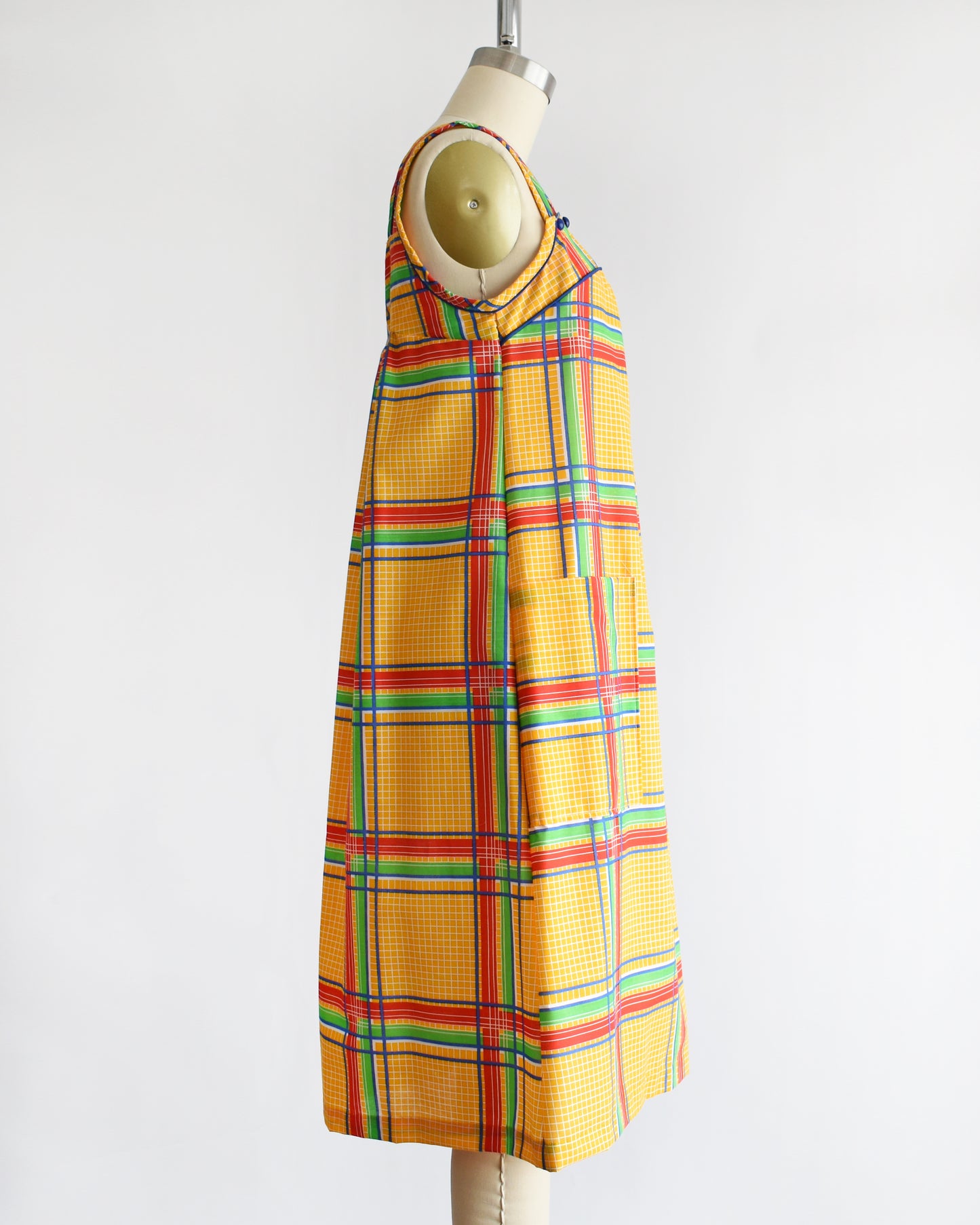 side view of a vintage 1970s yellow plaid dress on a mannequin against a white background