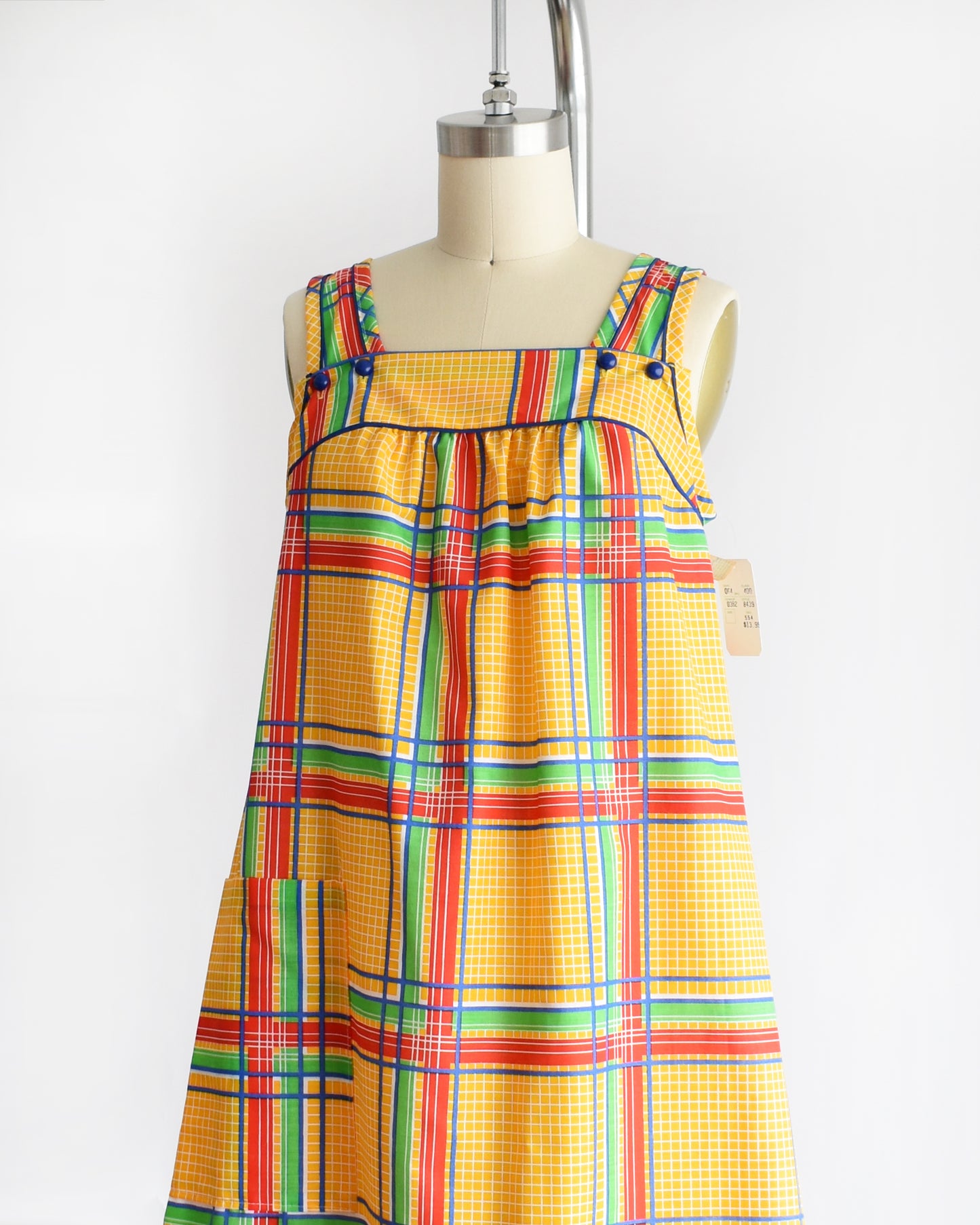 side front view of a vintage 1970s yellow plaid dress on a mannequin against a white background